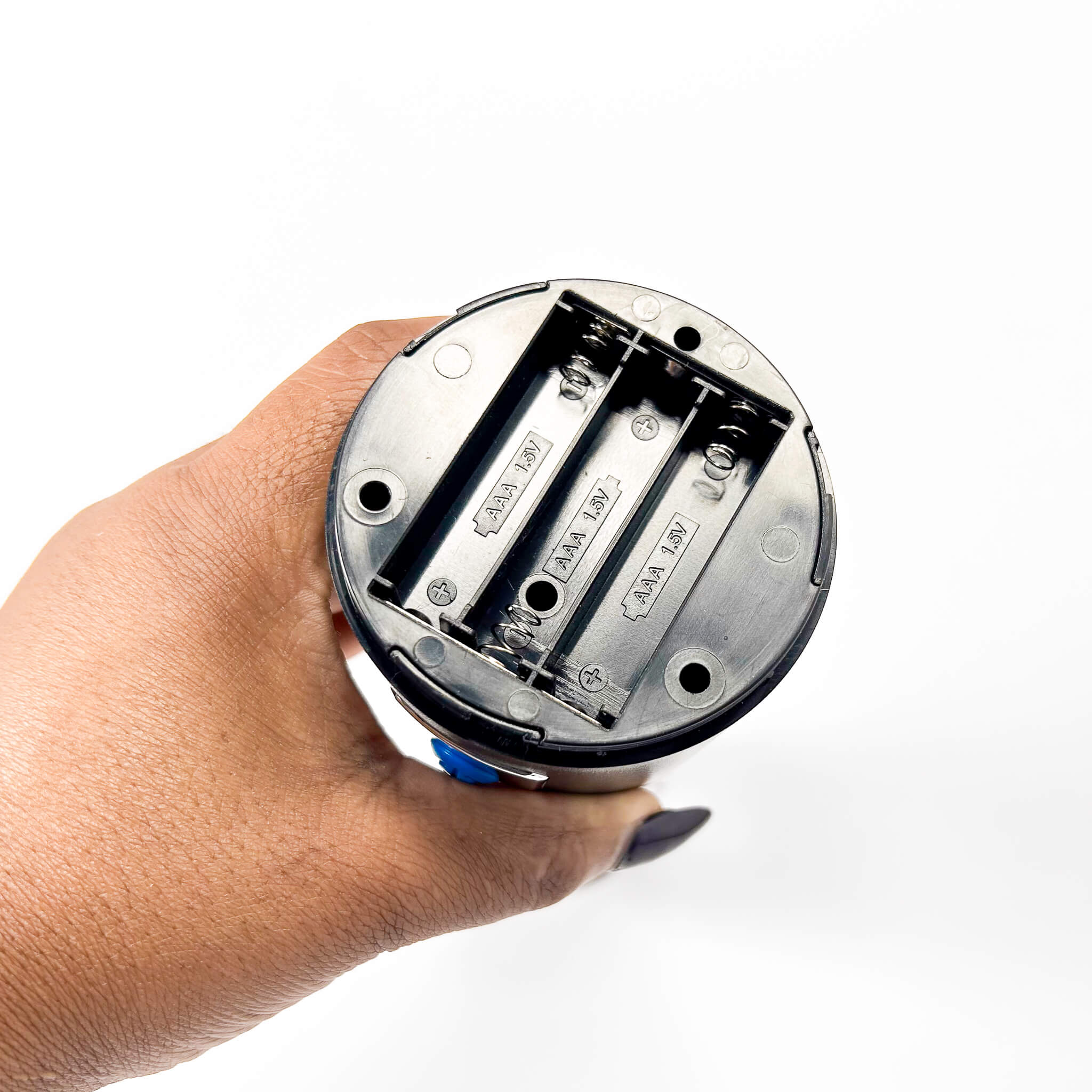 Hand holding a cylindrical electronic device with visible wiring on a white background