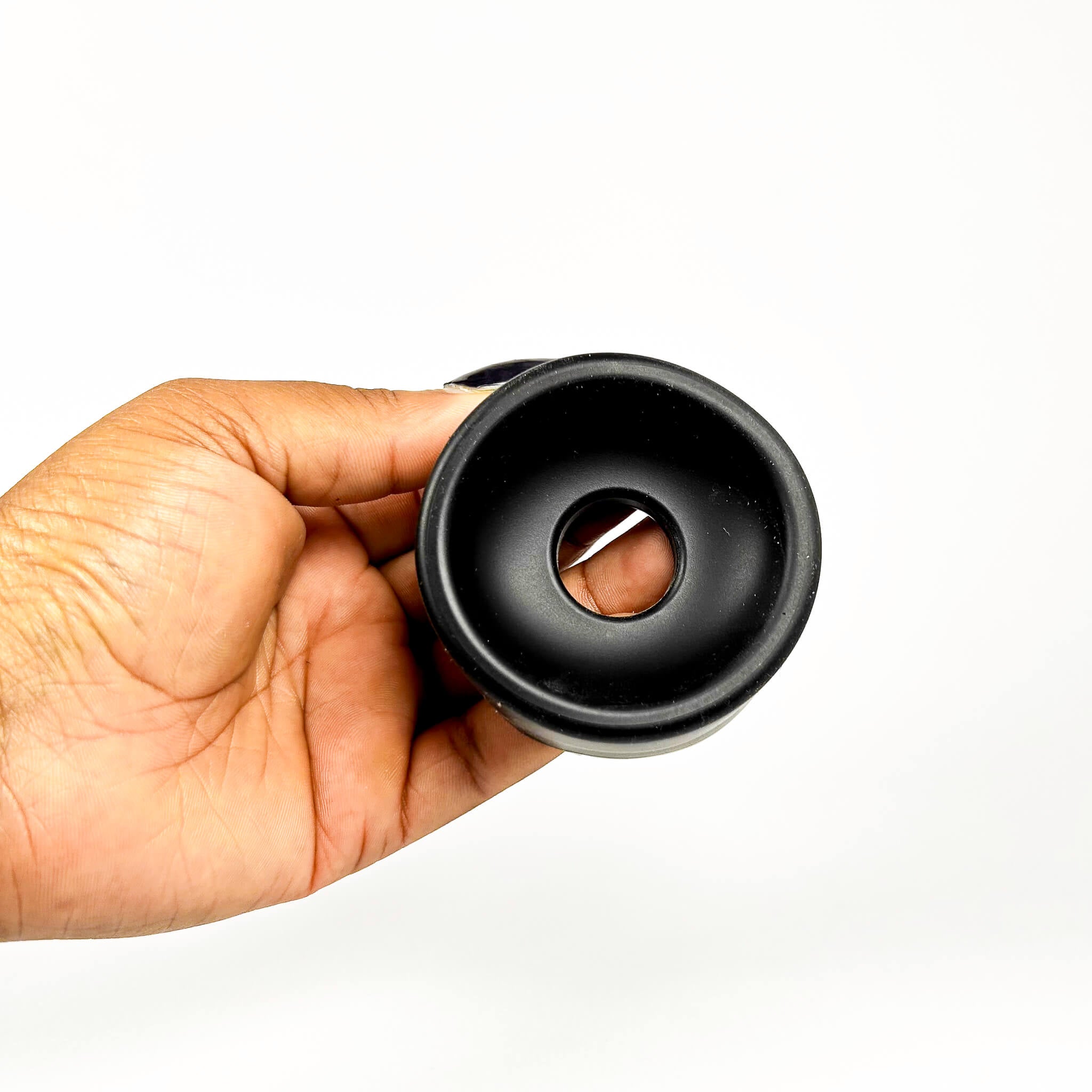 Hand holding a black coffee filter against a white background