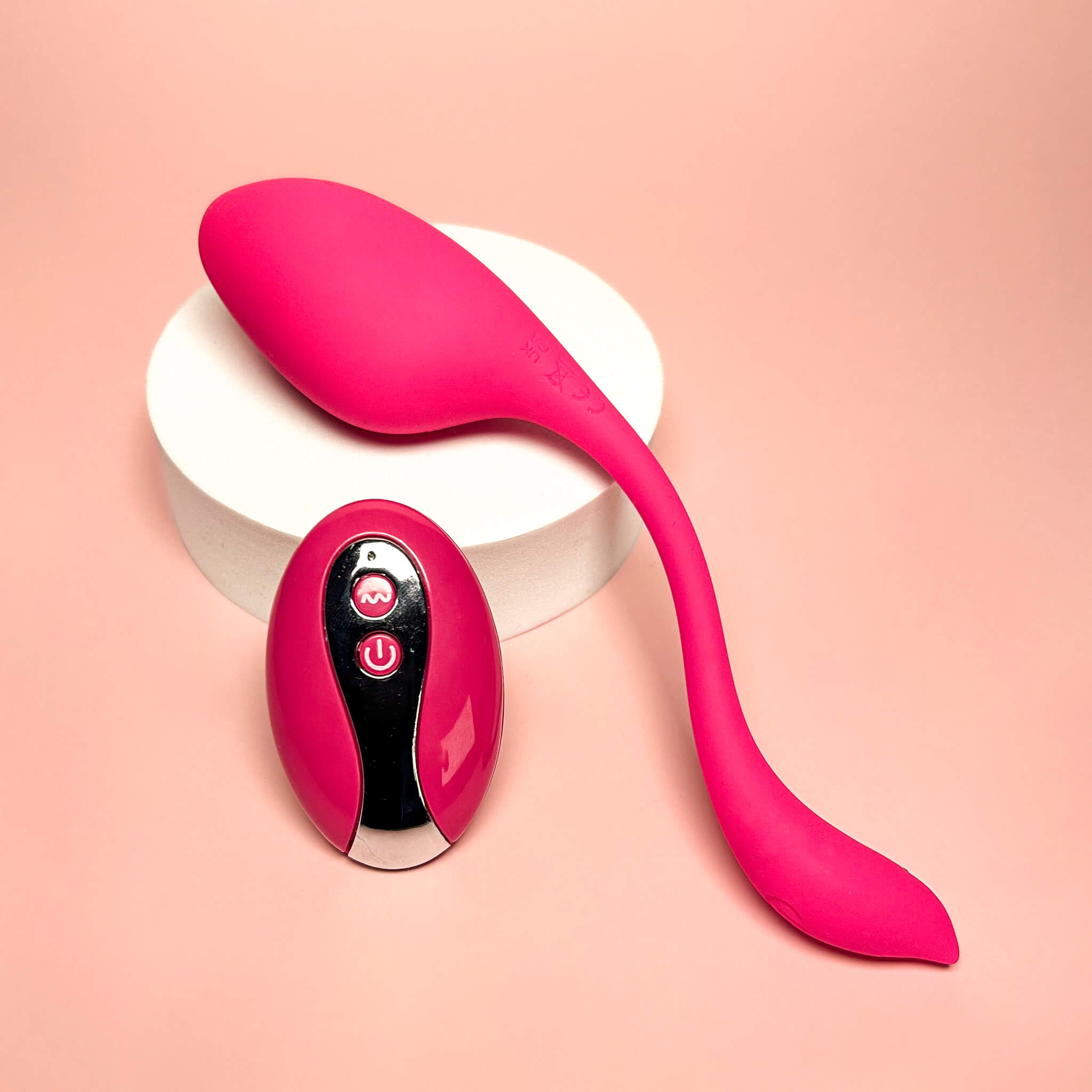 Pink electronic device with remote control on a pink background