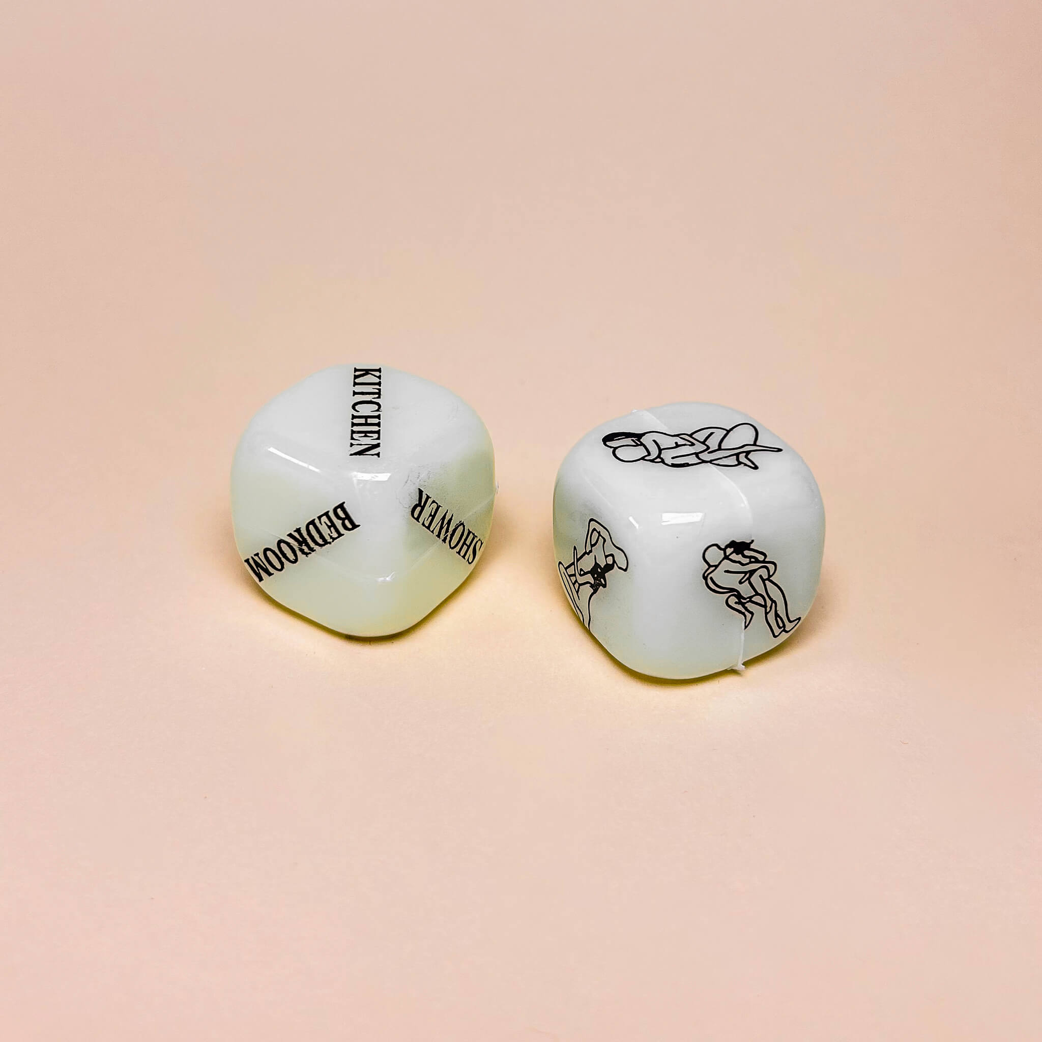 Two sex dice with black text and graphics on a beige background
