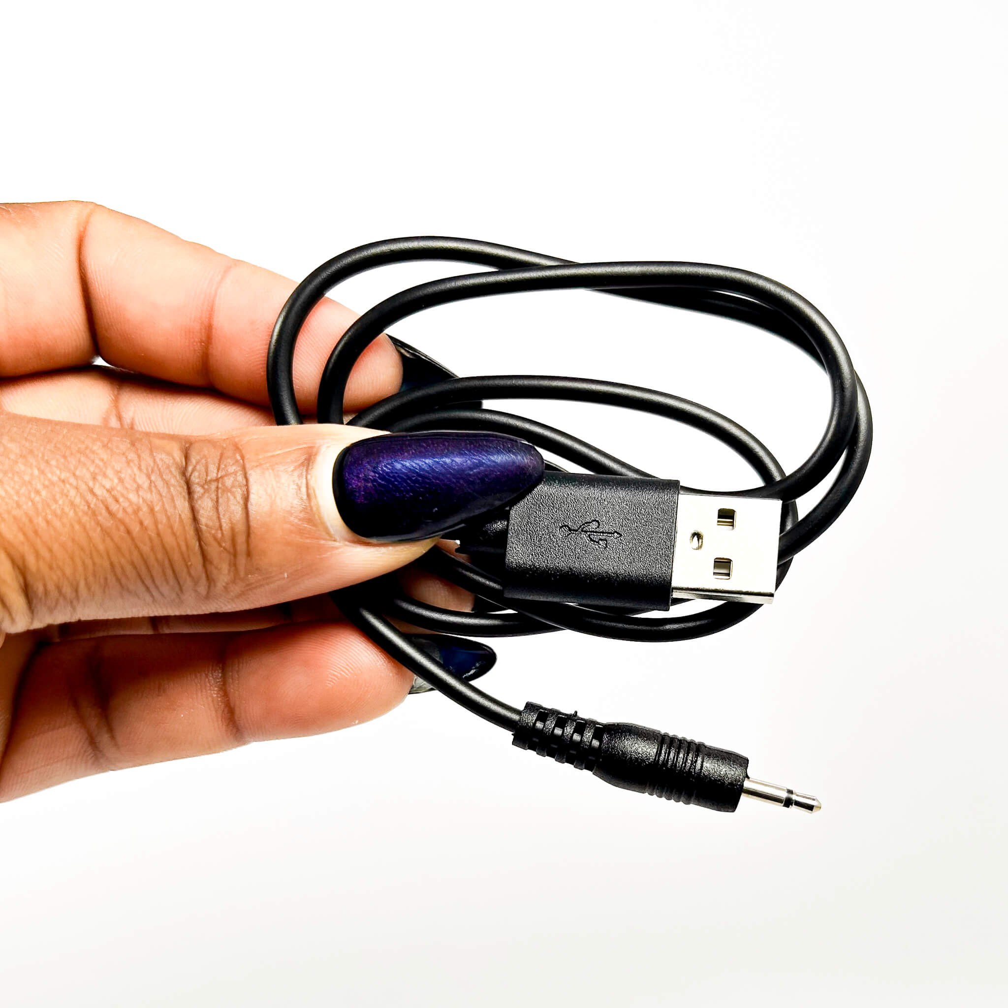 Hand holding a coiled USB cable with a white background