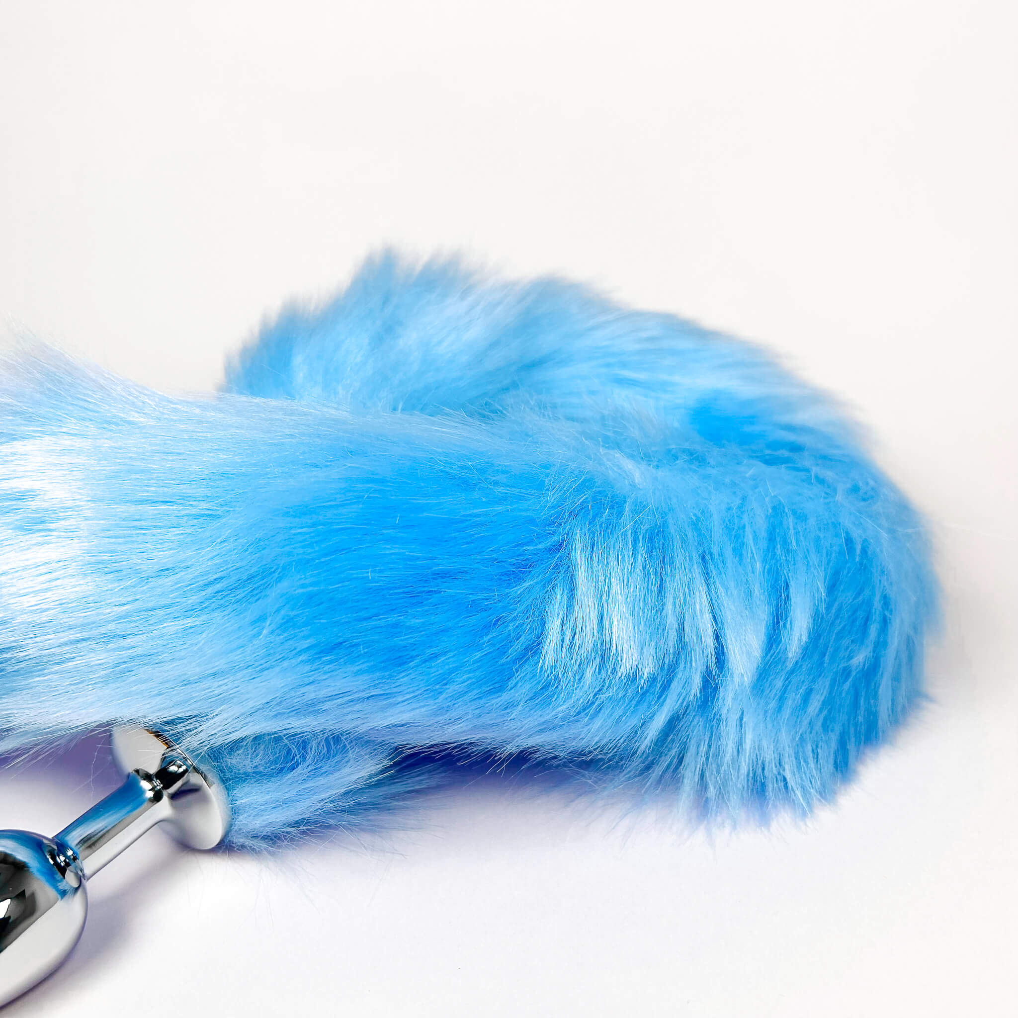 blue long butthole tail plug with a metallic base on a white background