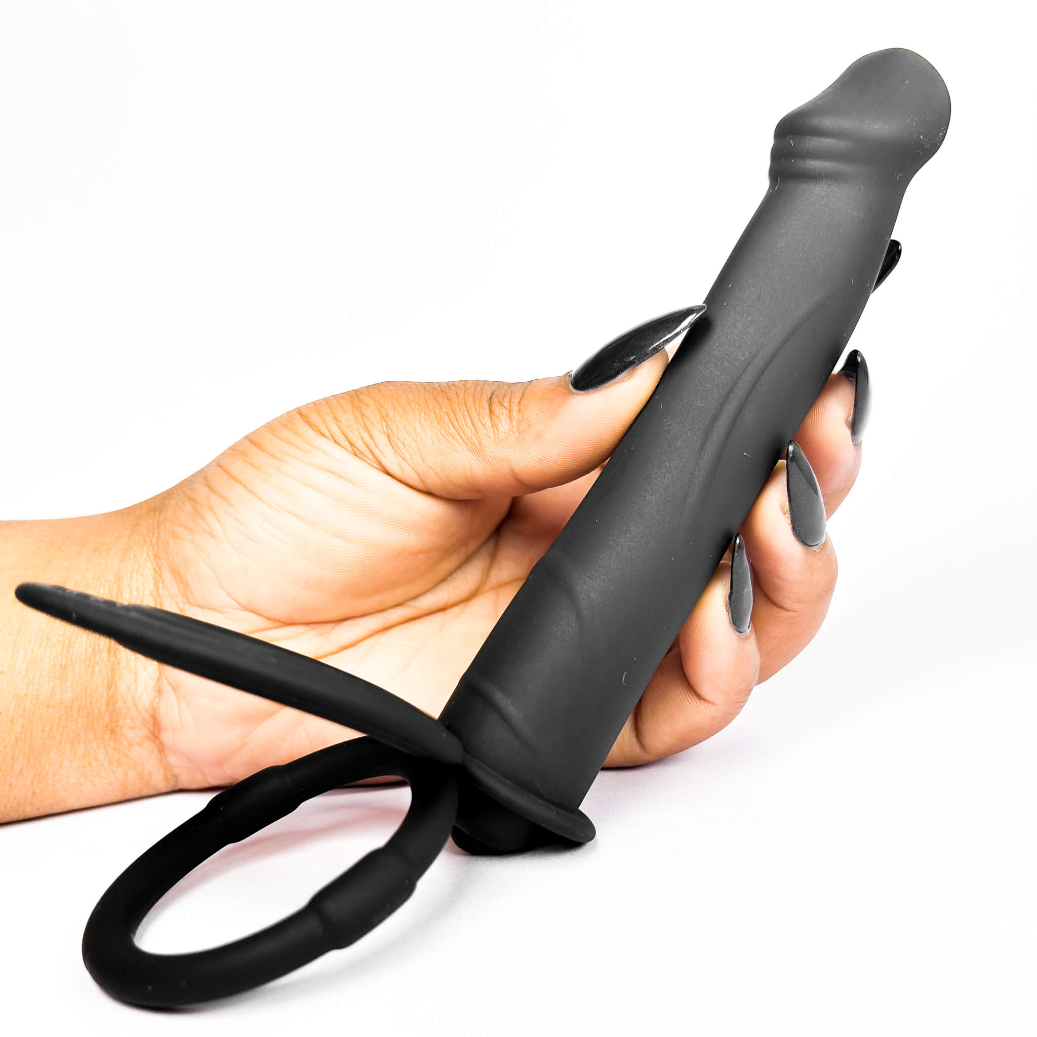 Hand holding a double penetration ring against a white background