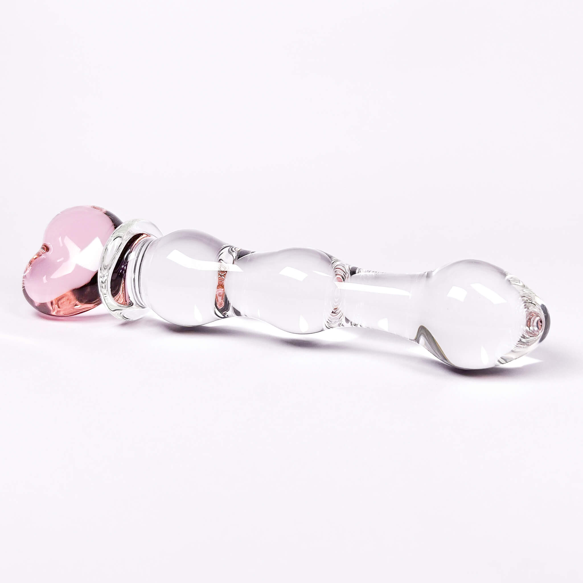 Glass dildo with pink and clear components on a white background