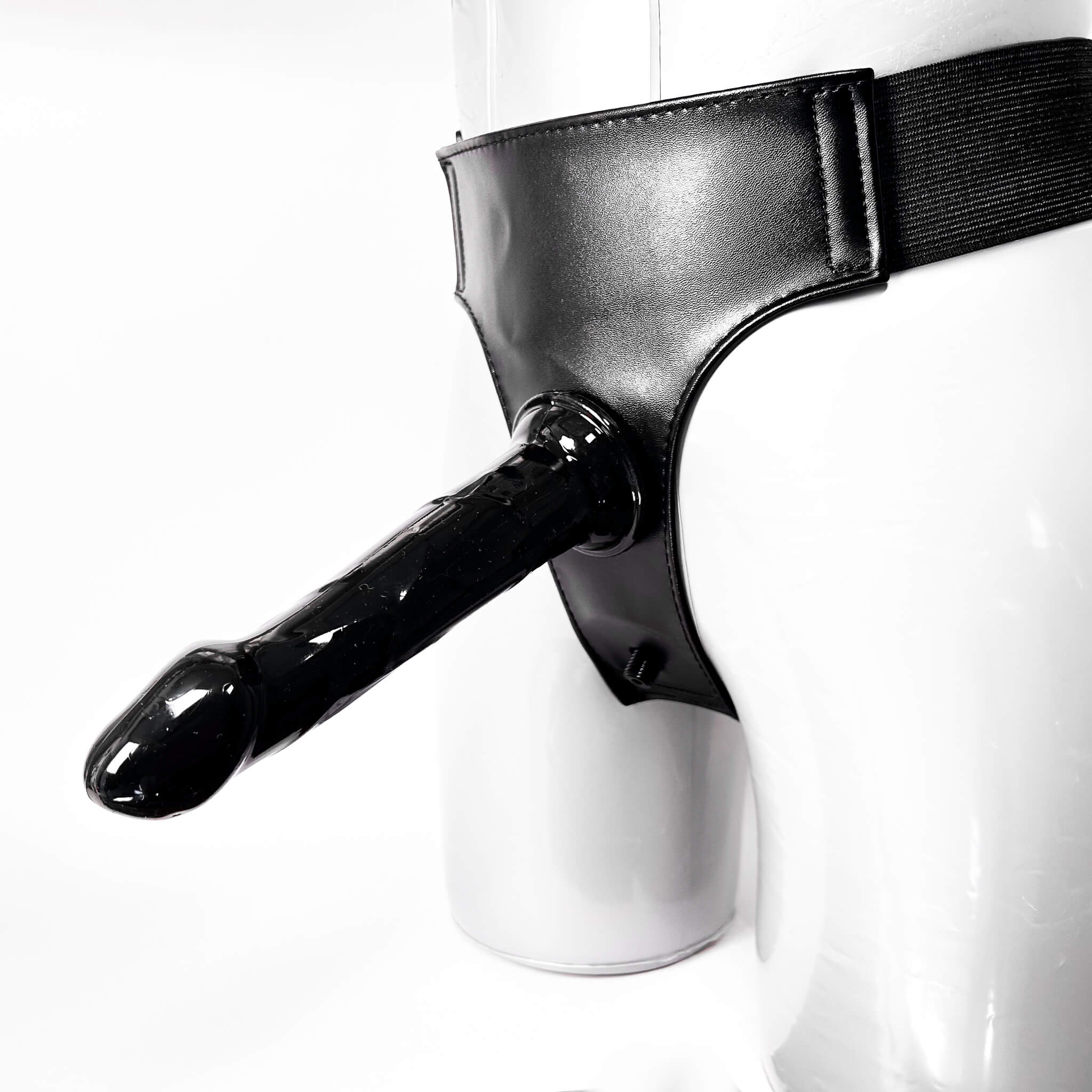 Black leather harness with a dildo on a white background