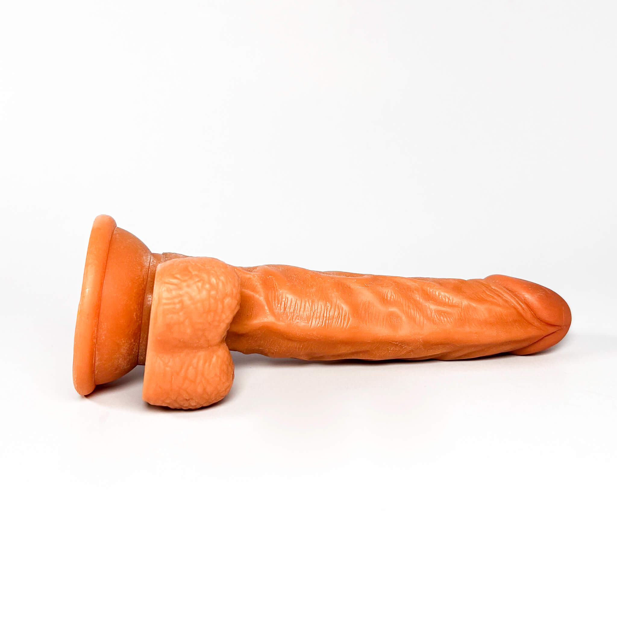 light brown dildo toy on a white background