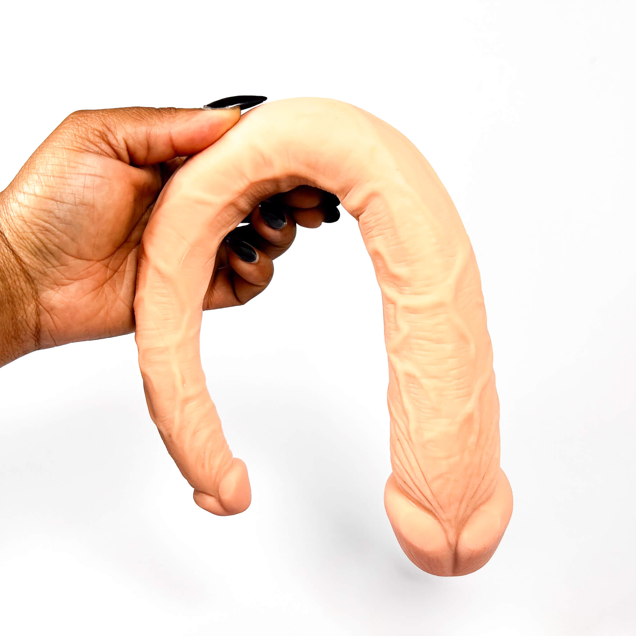 Hand holding a double-ended dildo on a white background