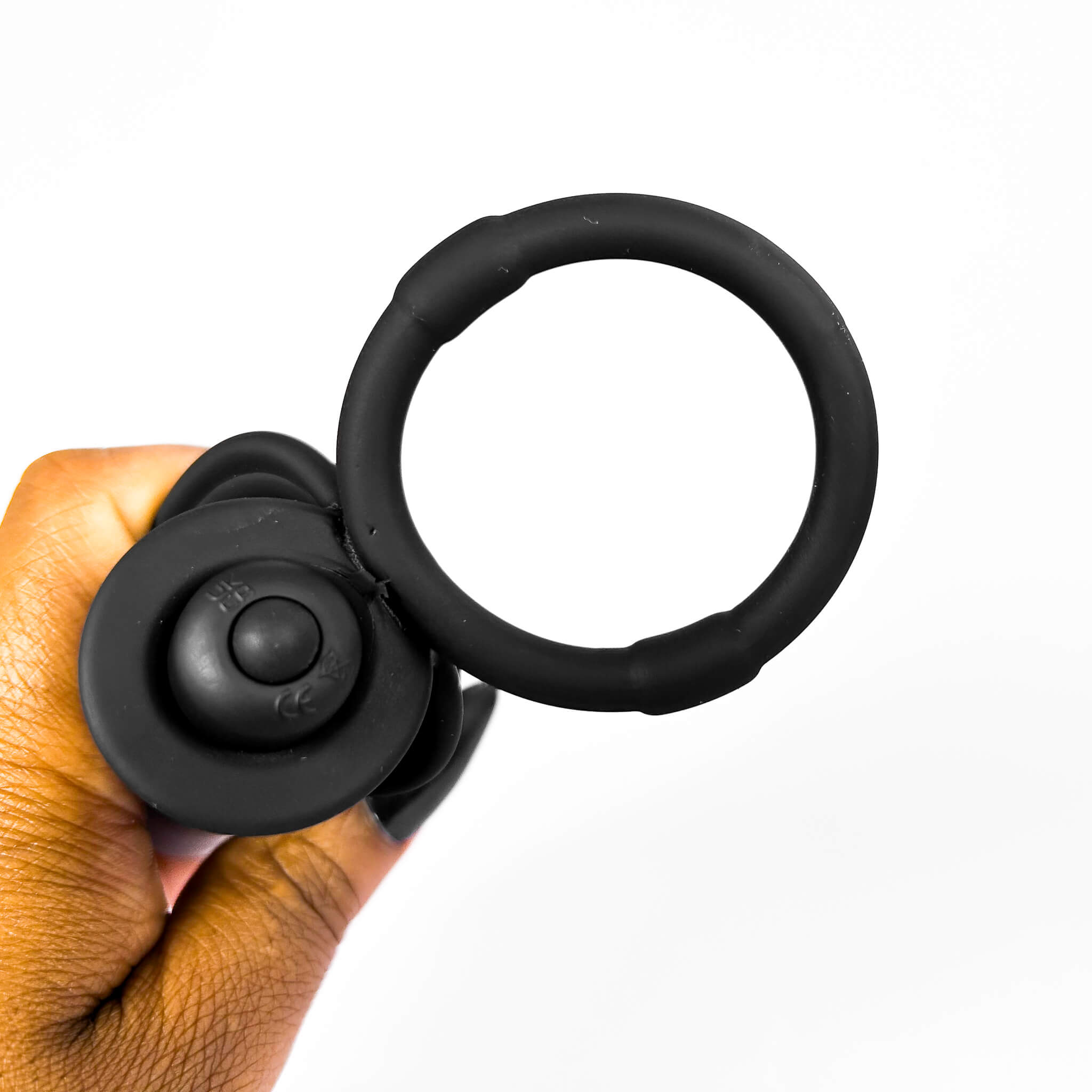 double penetration ring held by a hand on a white background