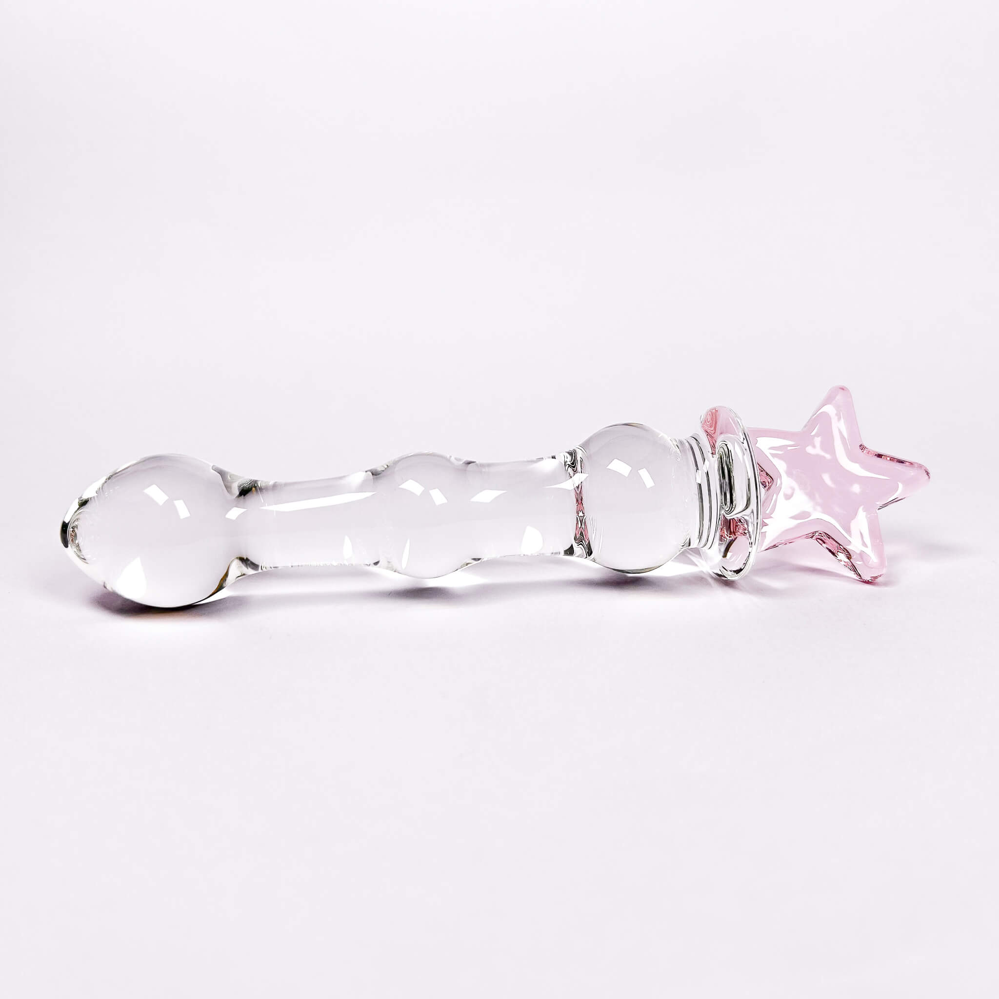 Glass dildo with a pink star on a white background