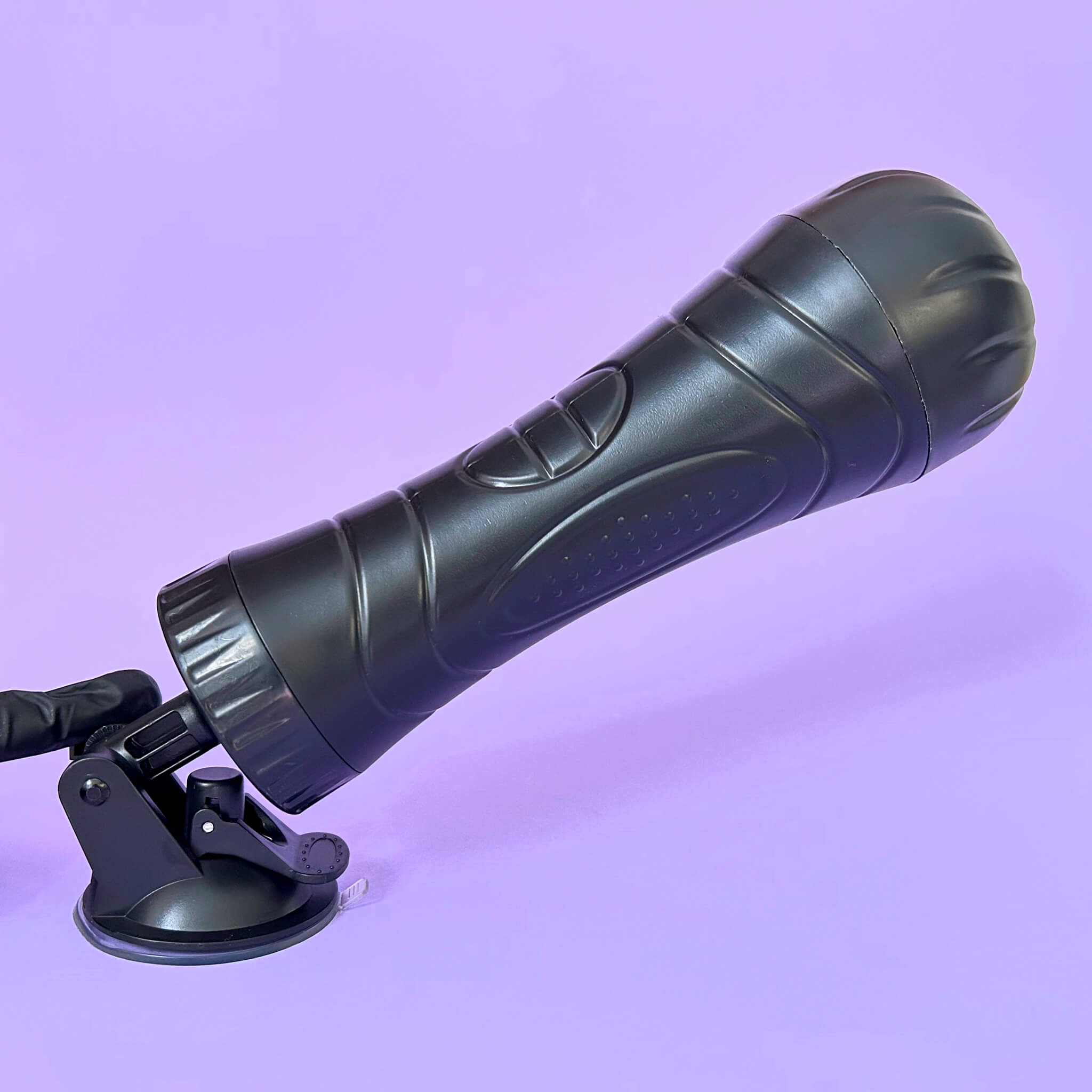 Black fleshlight with a suction cup on a purple background