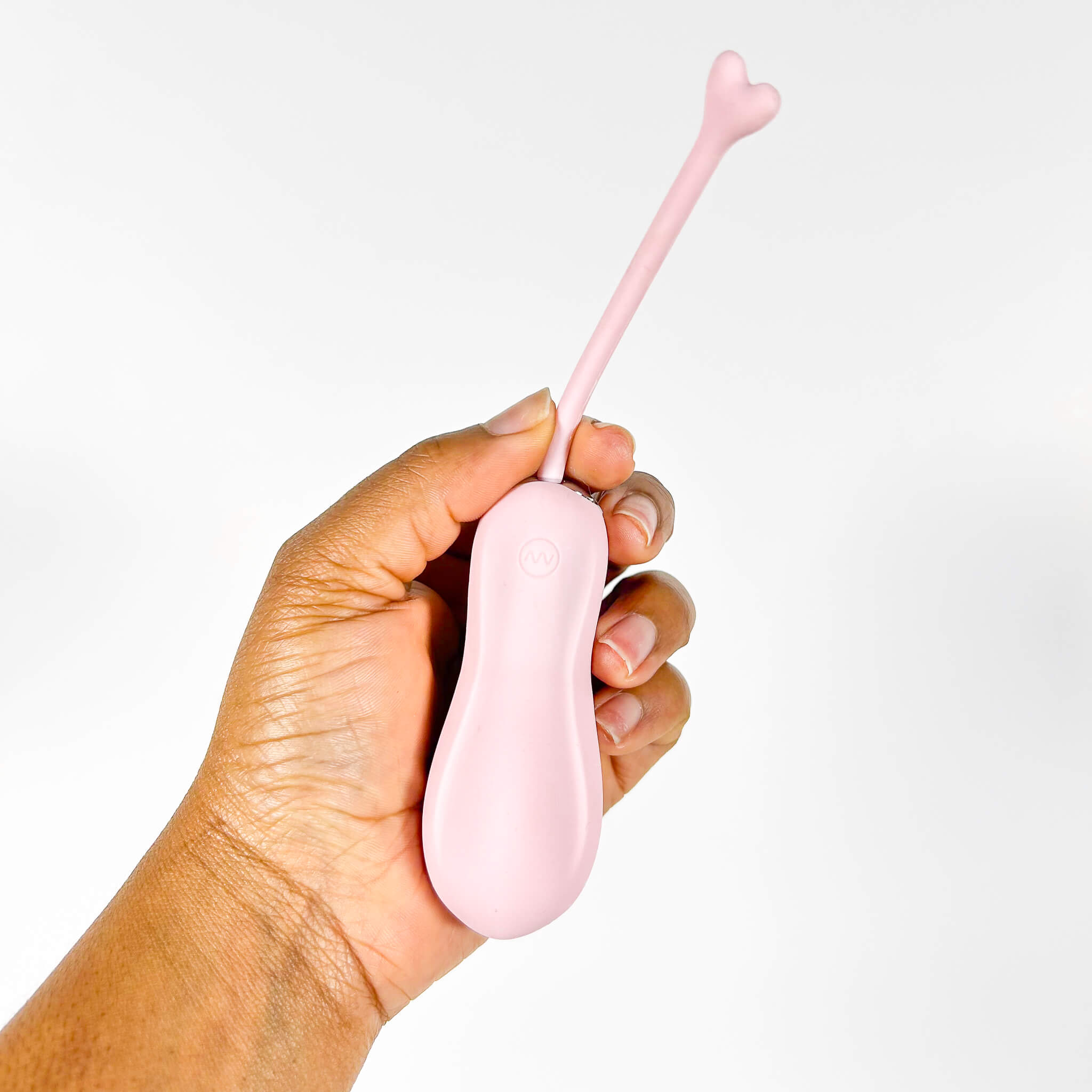 Hand holding a pink heart-shaped vibrator against a white background