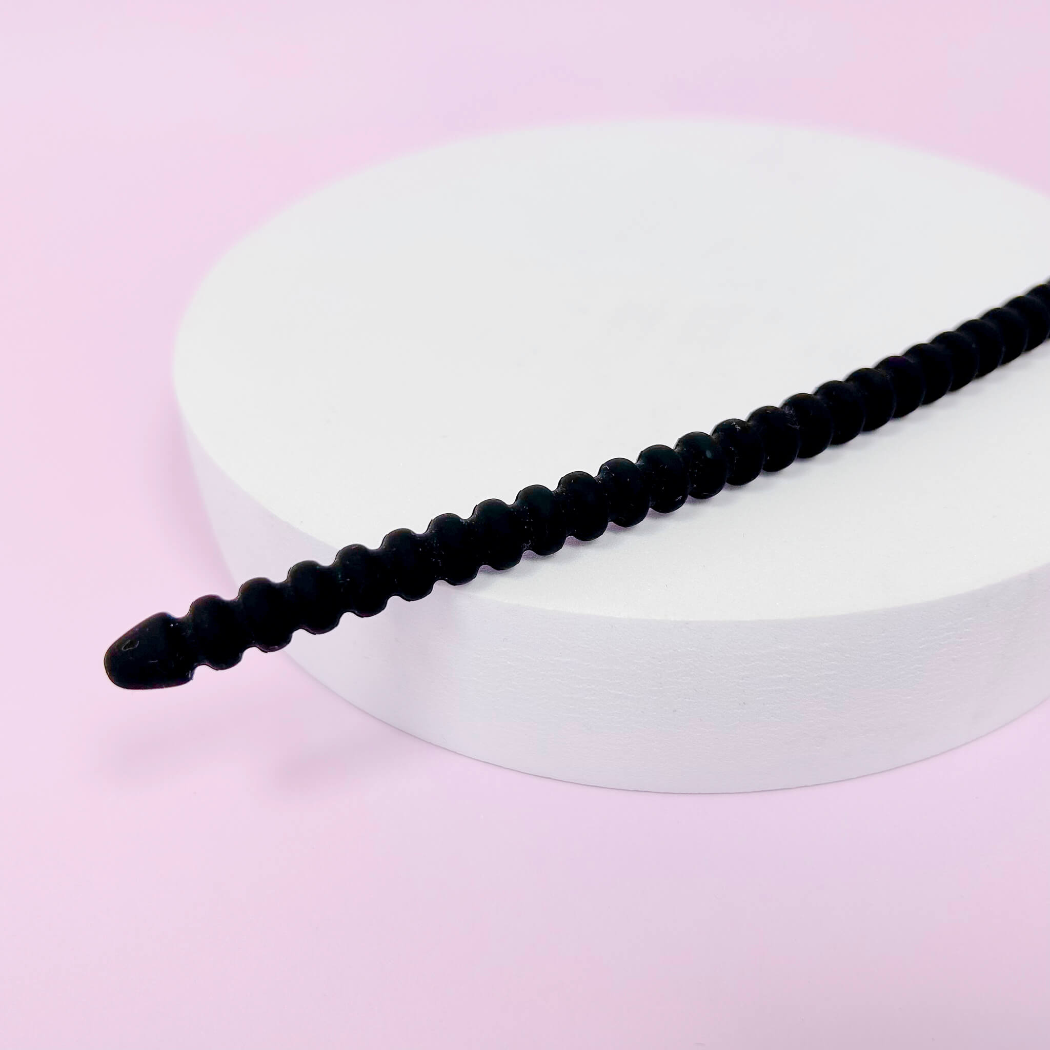 large ribbed Silicone Urethral Plugs on a white circular object with a pink background