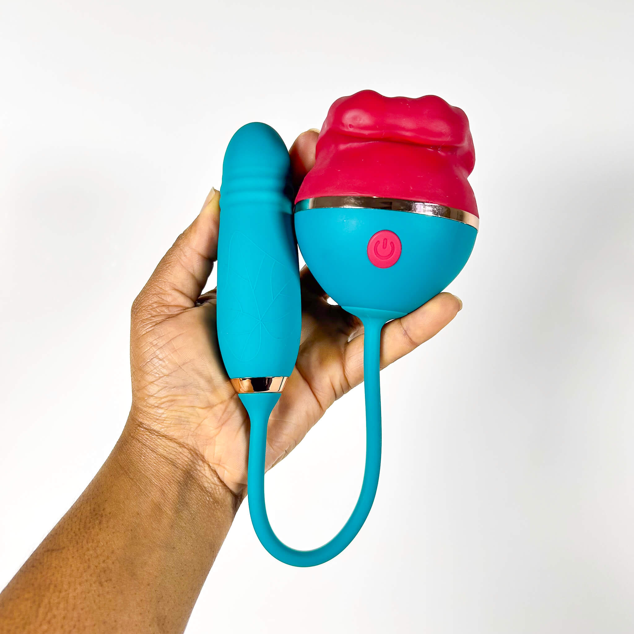 Hand holding a blue and pink licking tongue vibrator on a white background