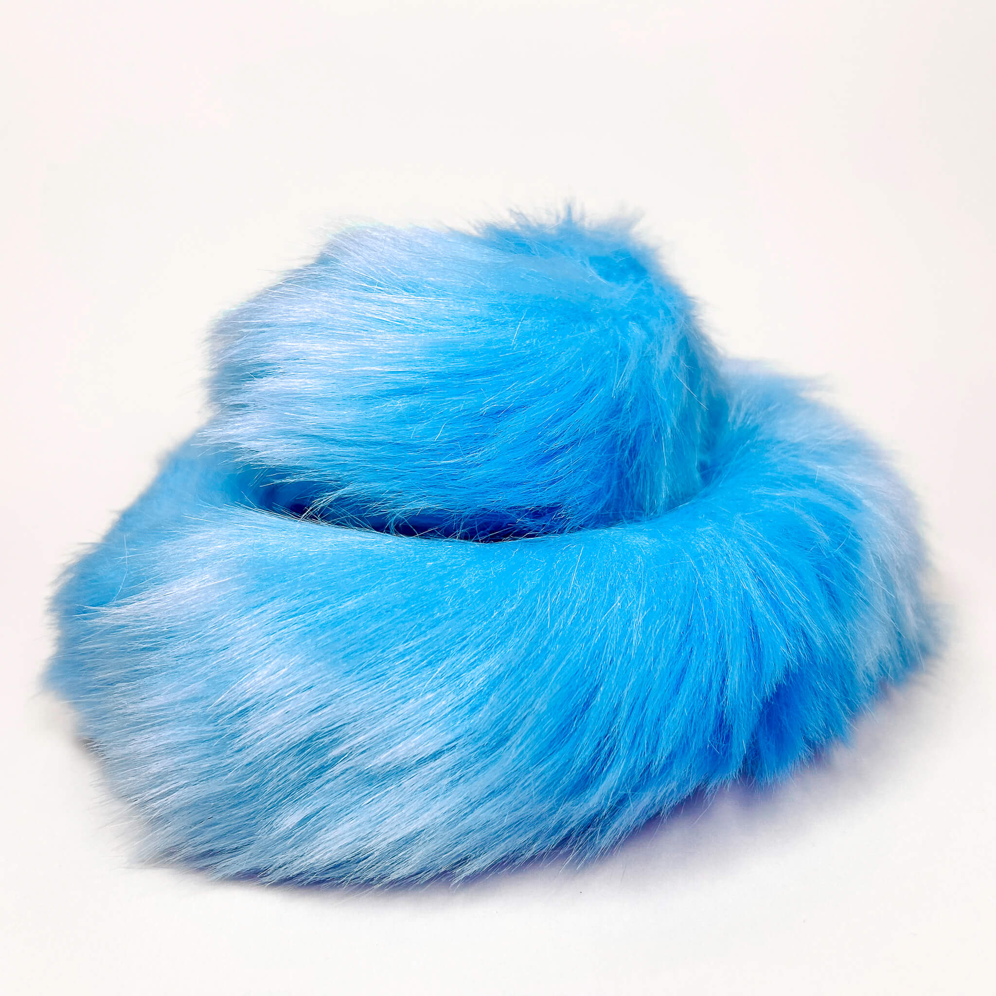 Blue furry fox tail butt plug on a white background