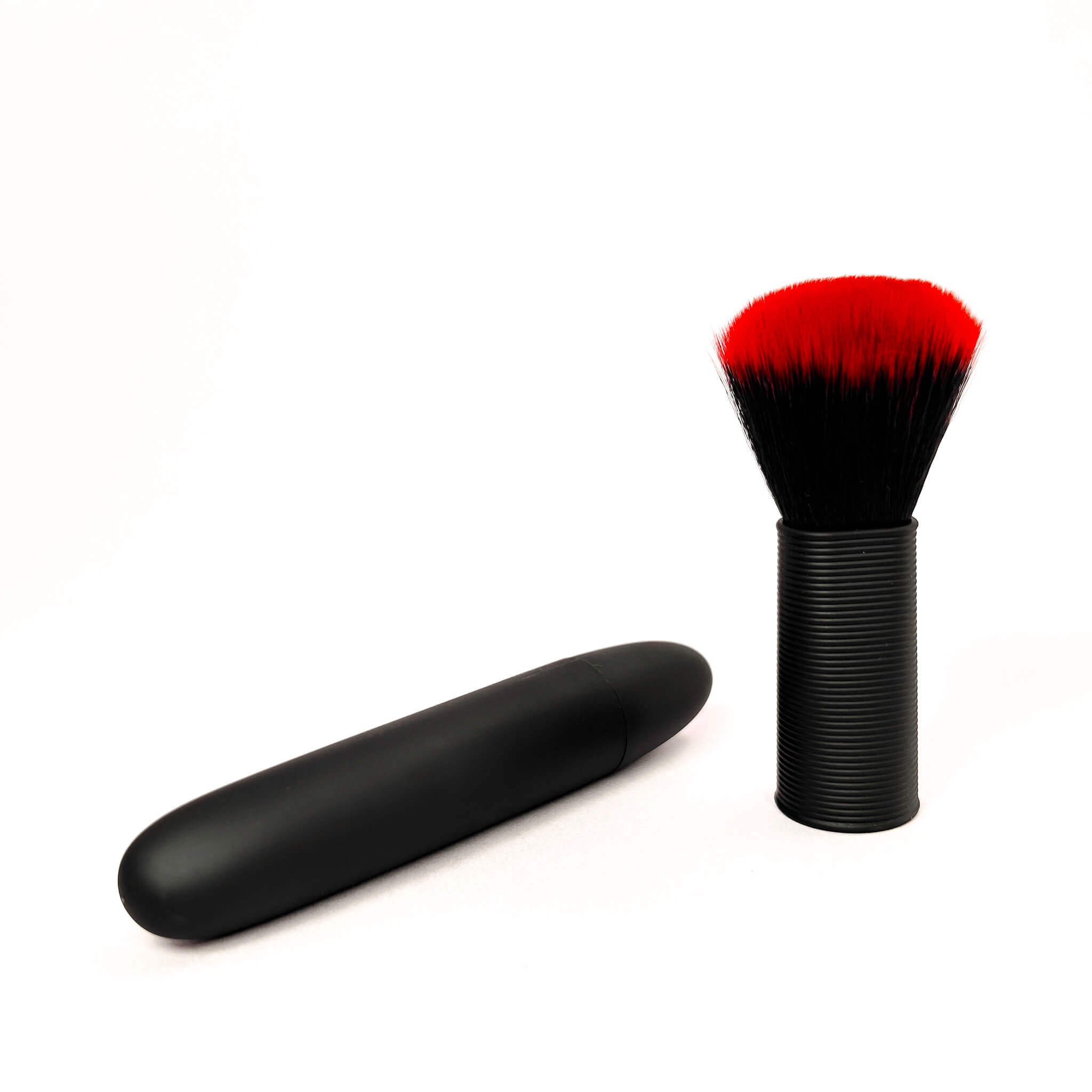 Black makeup brush vibrater with red bristle head on a white background