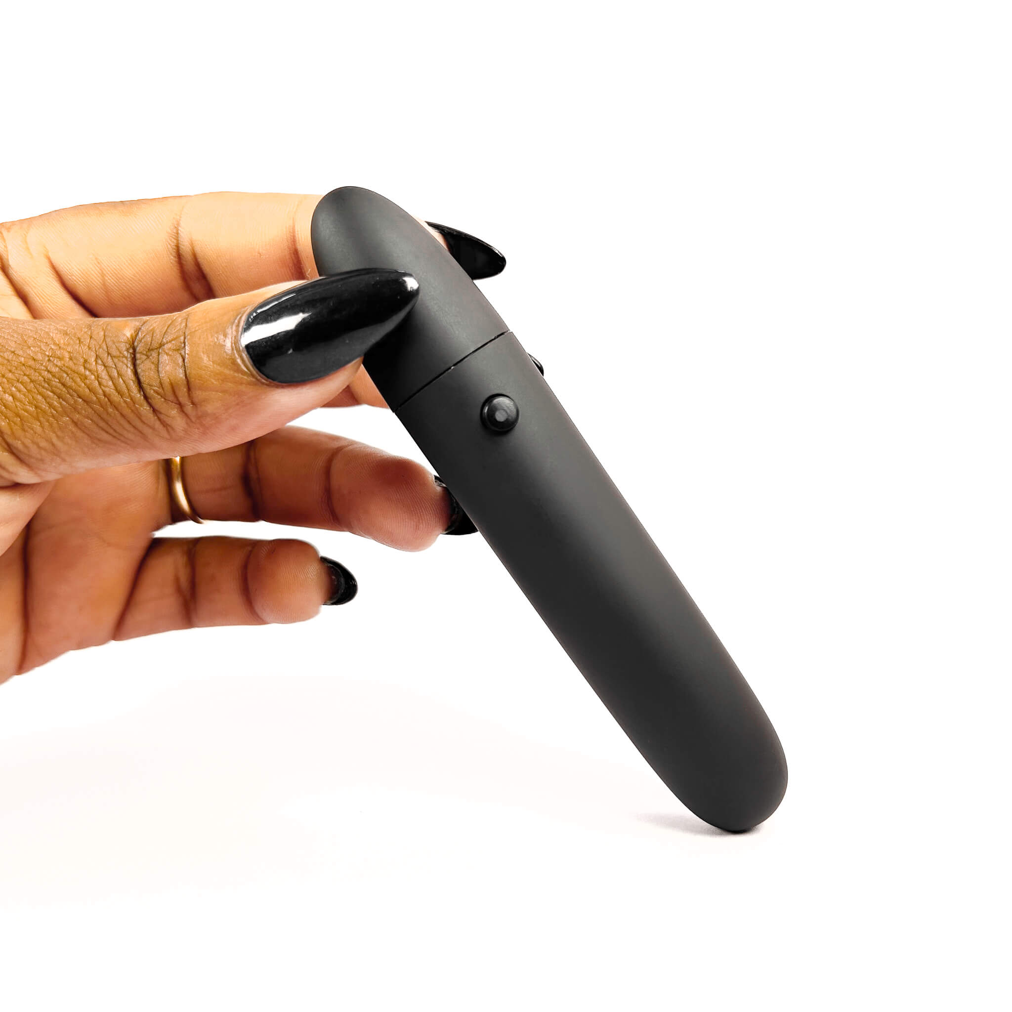 Hand holding a black makeup brush vibrator on a white background
