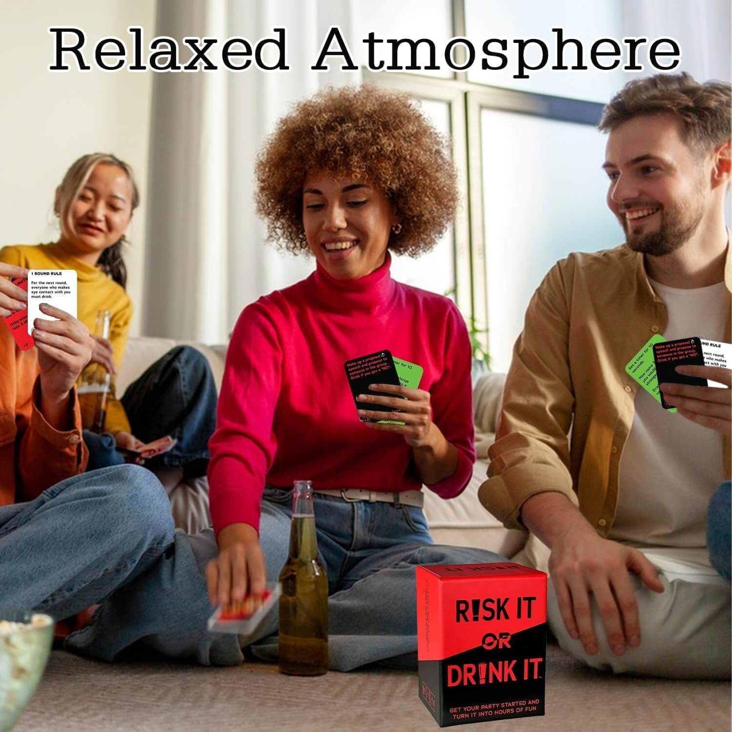 Three people playing a card game with 'Risk It or Drink It' cards on a couch.