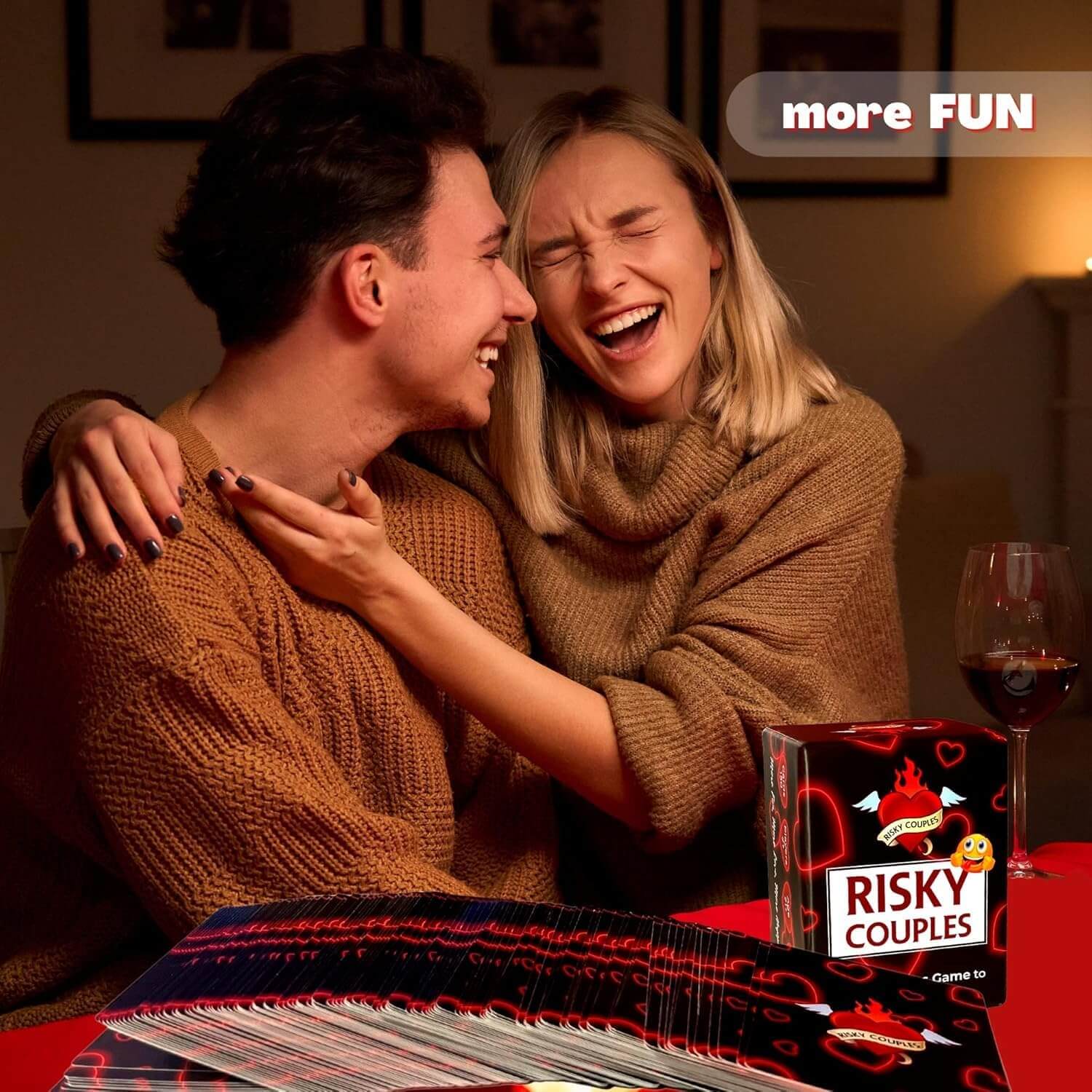 Two people laughing together with a 'Risky Couples' game box in front of them.