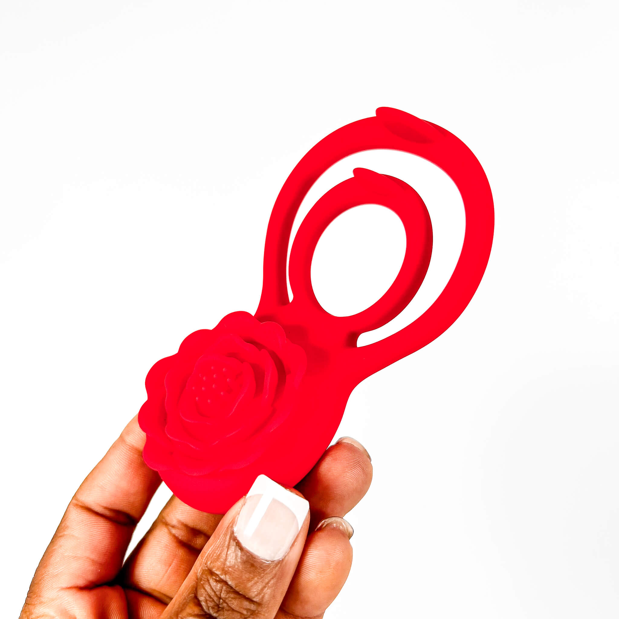 Red rose cock ring held by a hand on a white background