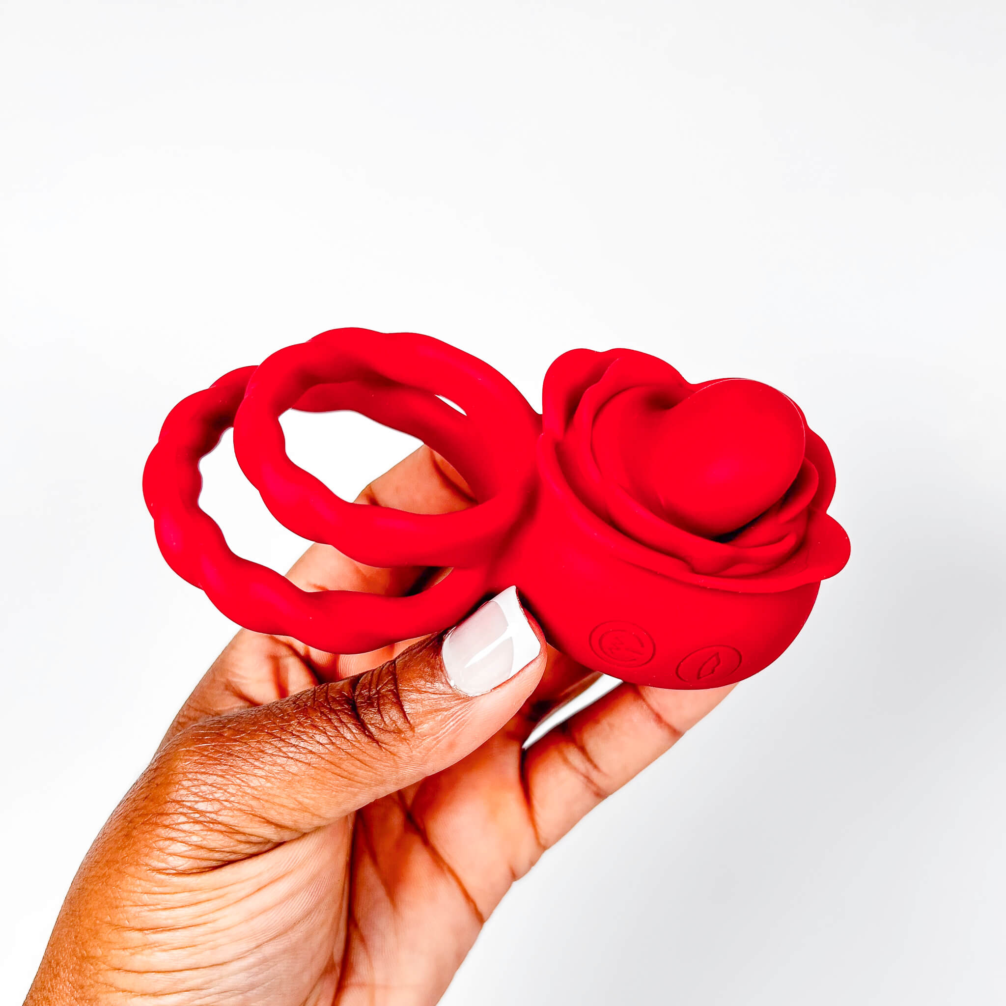 Red rose tongue cock ring held in a hand against a white background