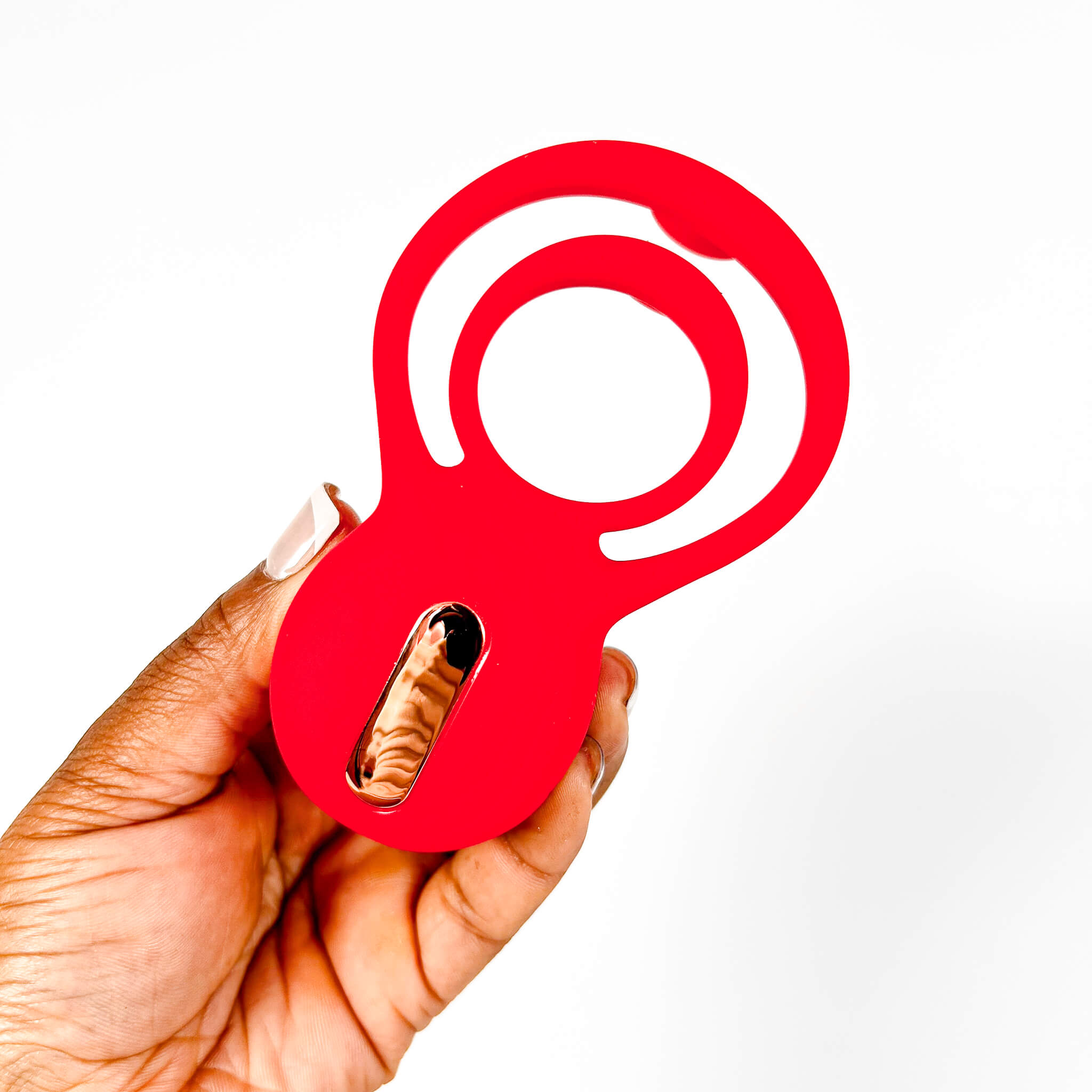Red vibrating rose cock ring with a white circle held by a hand on a white background