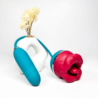 2 in 1 Big Mouth Clit Licking Vibrator with a white vase containing yellow flowers on a white background