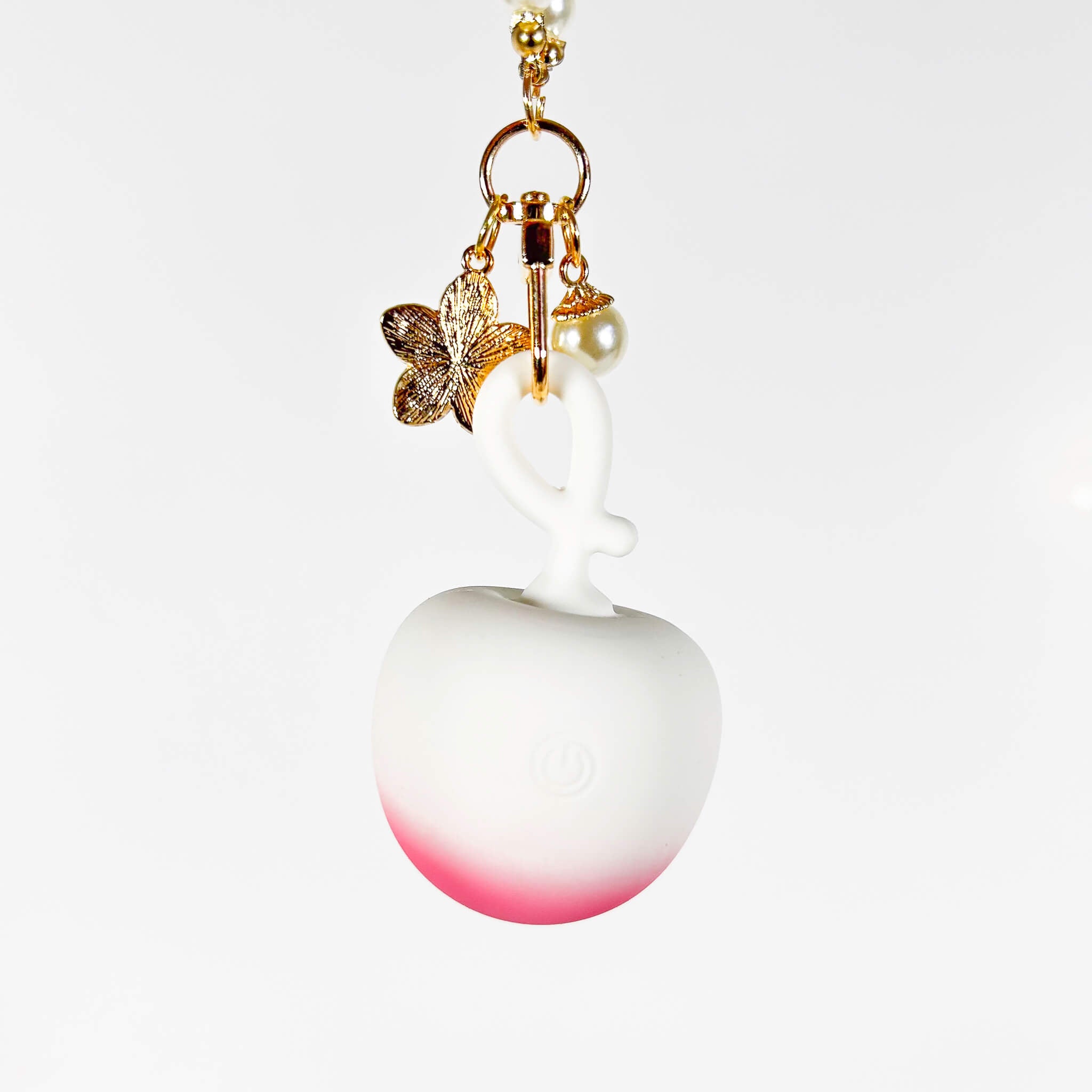 App Controlled Discreet Mini Vibrator with a white and pink gradient apple, gold butterfly, and pearl accent on a white background