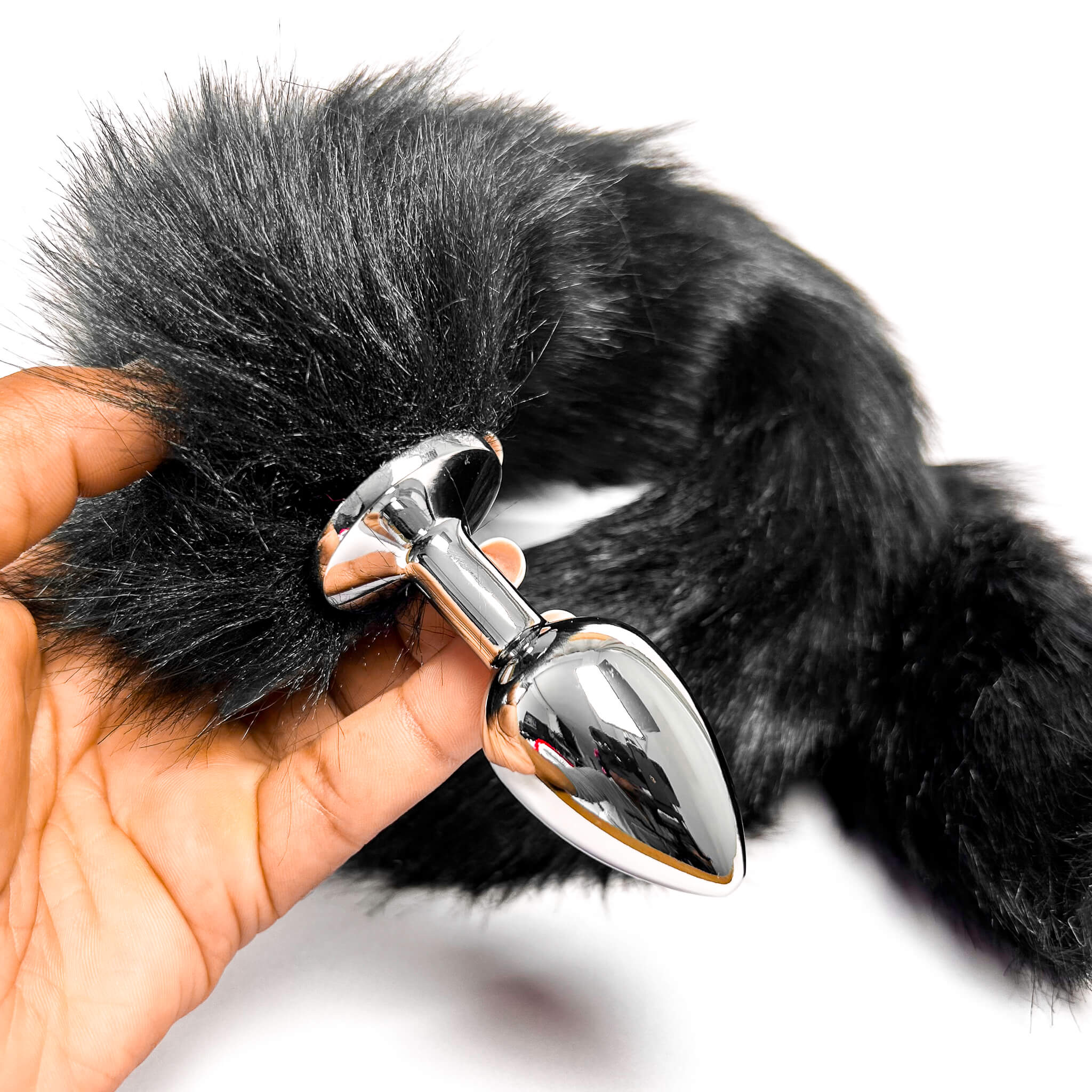 Black Extra Long Tail With Metal Butt Plug held by a hand on a white background