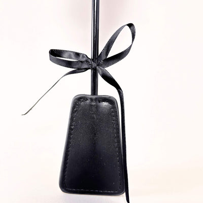 Black flogger crop with a black ribbon on a white background