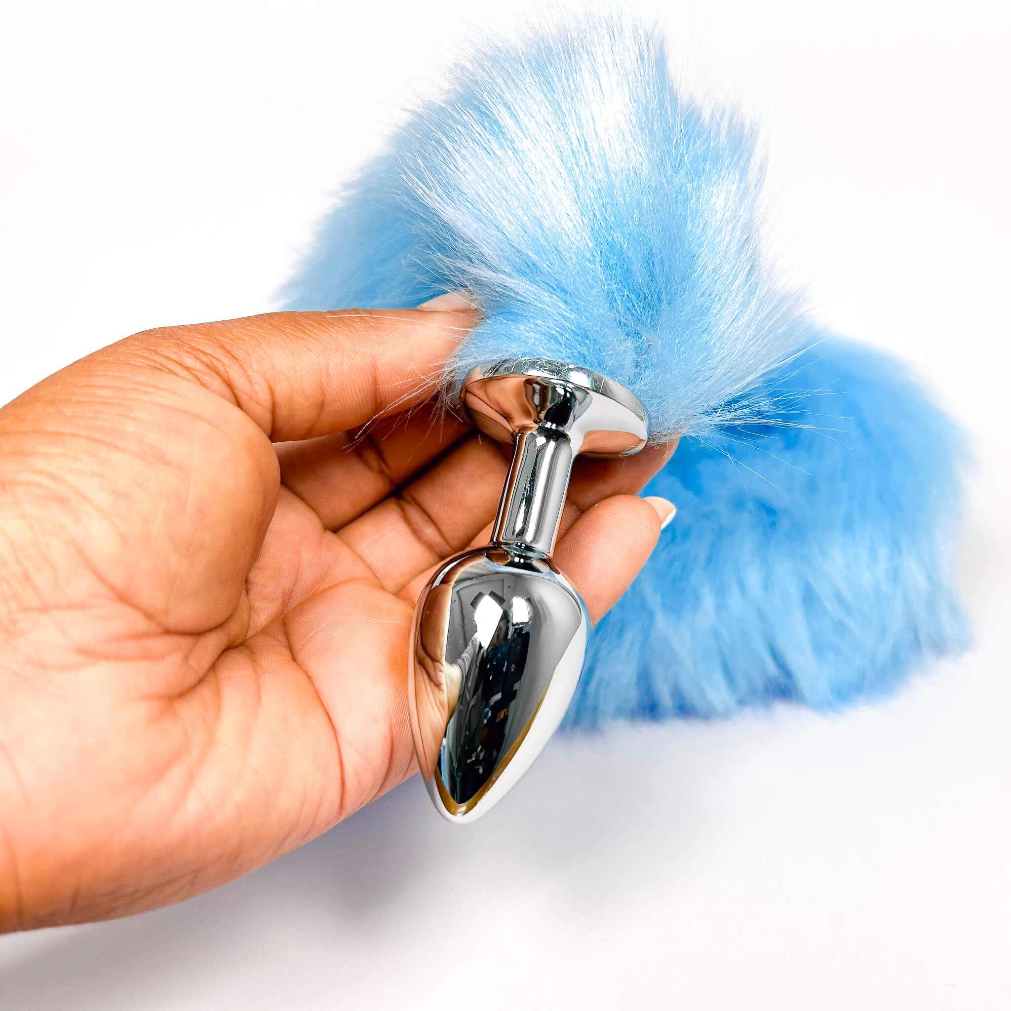 Blue Extra Long Tail With Metal Butt Plug attachment held by a hand on a white background