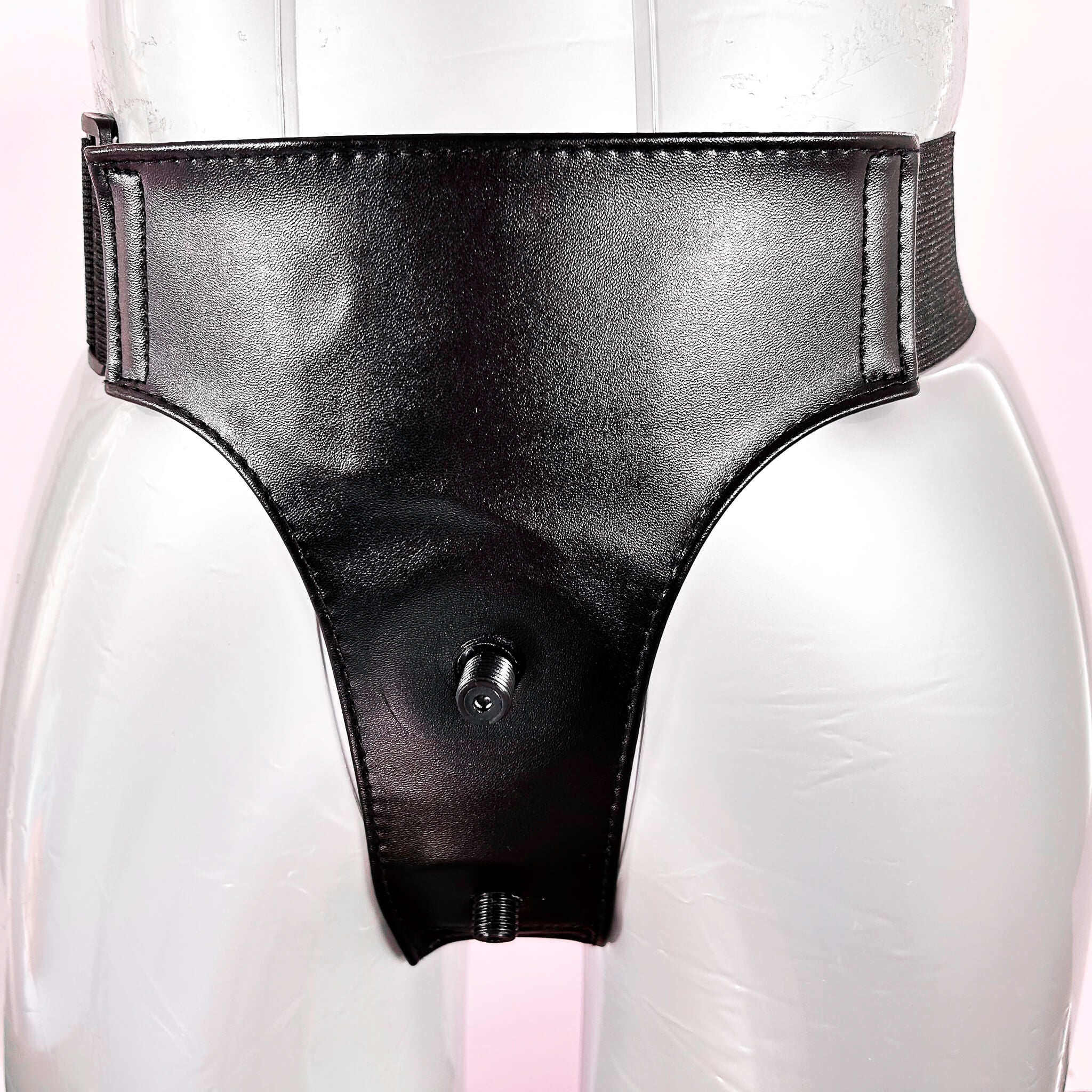 Black leather strapon harness on a mannequin with a white background