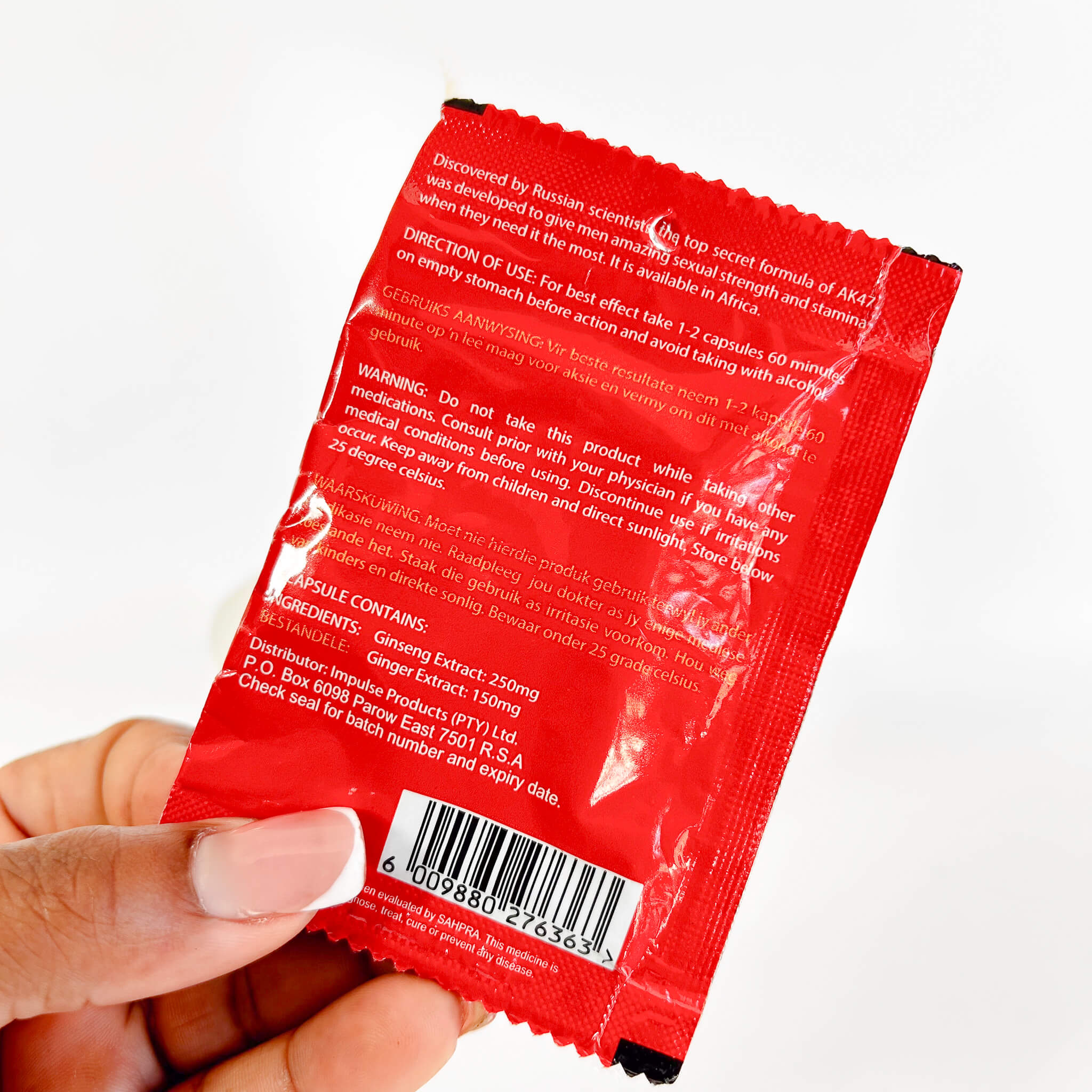 Dr Lee AK47 Value Pack Capsules (6's) with text and a barcode held by a hand on a white background