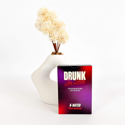 Drunk or Love game box with a decorative vase and flowers on a white background