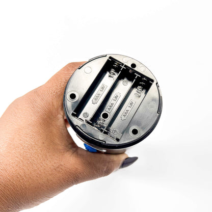 Hand holding a cylindrical electronic device with visible wiring on a white background