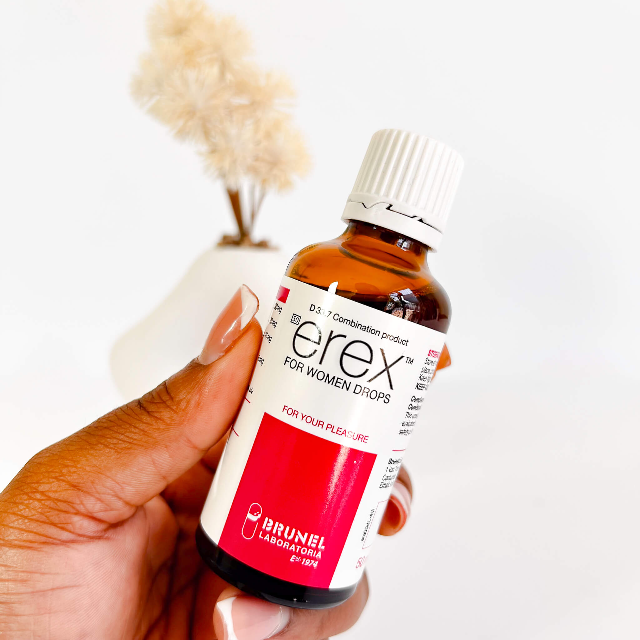 Bottle of 'erex for women drops' held by a hand with a blurred background