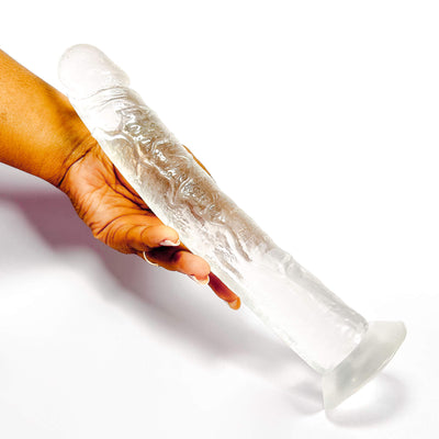 Hand holding a extra long clear dildo on a white background
