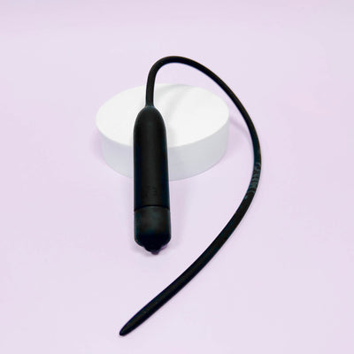 Extra Long Silicone Urethral Vibrator Plug on a light purple background