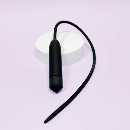 Extra Long Silicone Urethral Vibrator Plug on a light purple background
