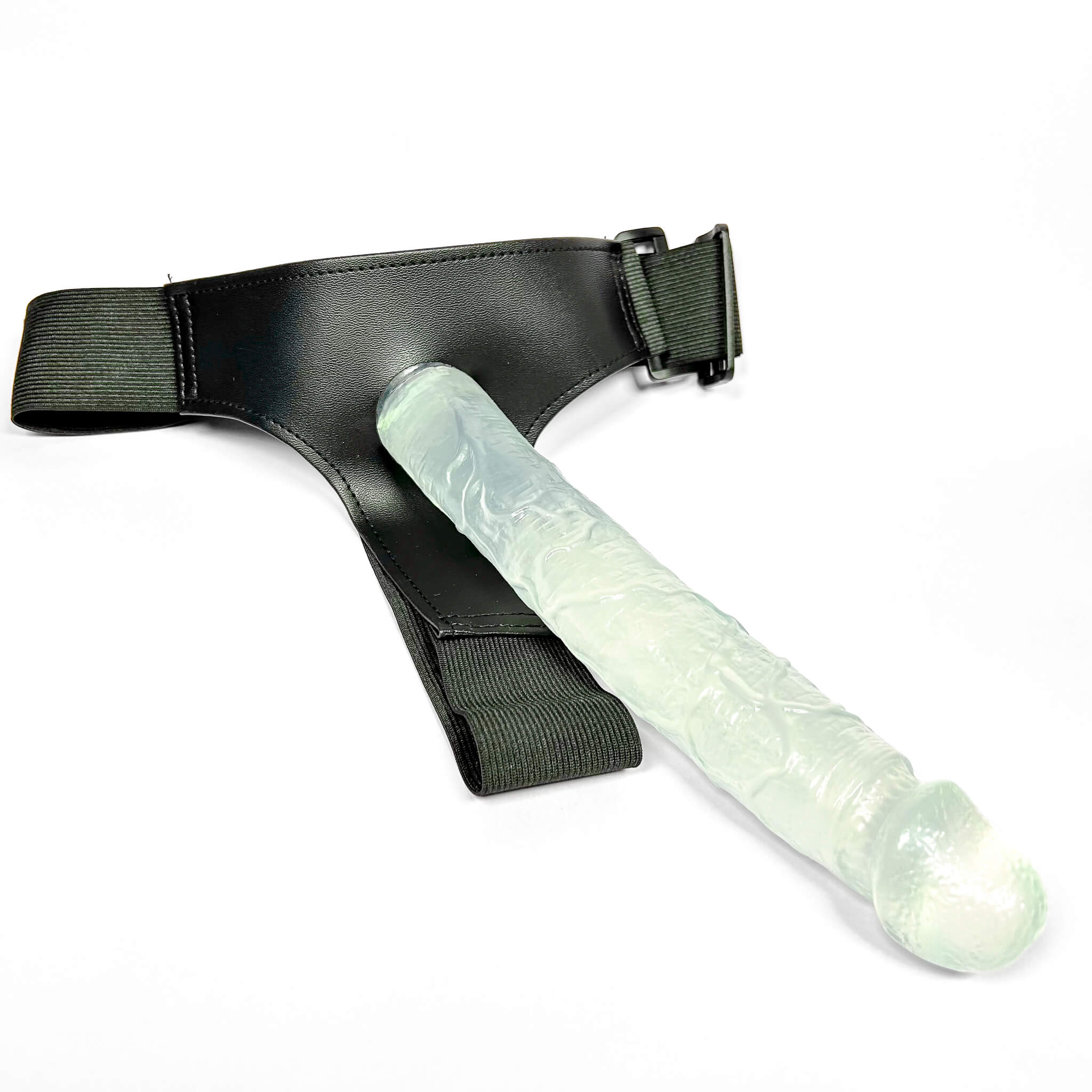 Glowing green strap on dildo with black leather harness on a white background