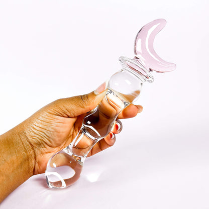 Fairy Wand Glass Dildo with Moon handle held by a hand on a white background