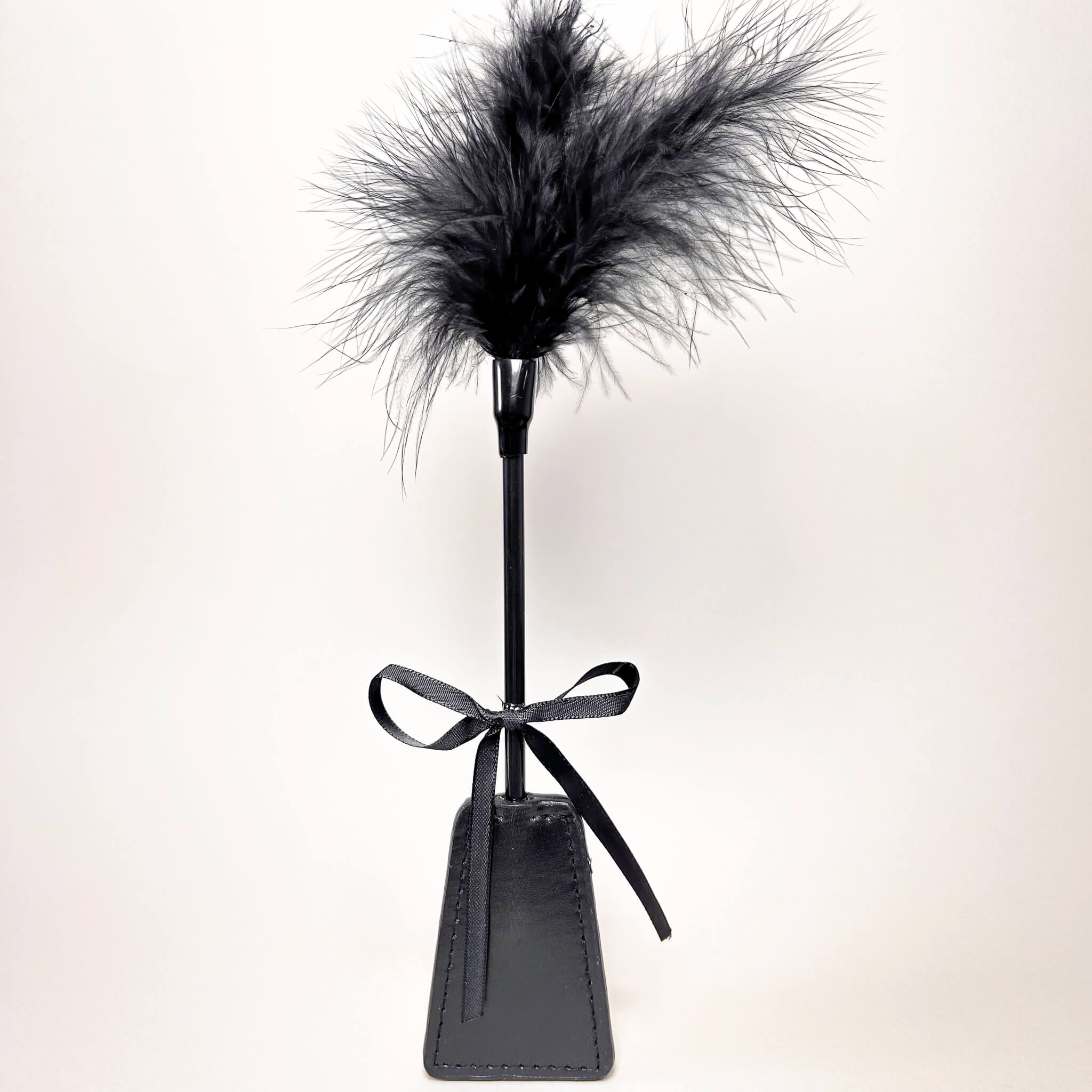 Black feathered stand with a black leather base on a white background