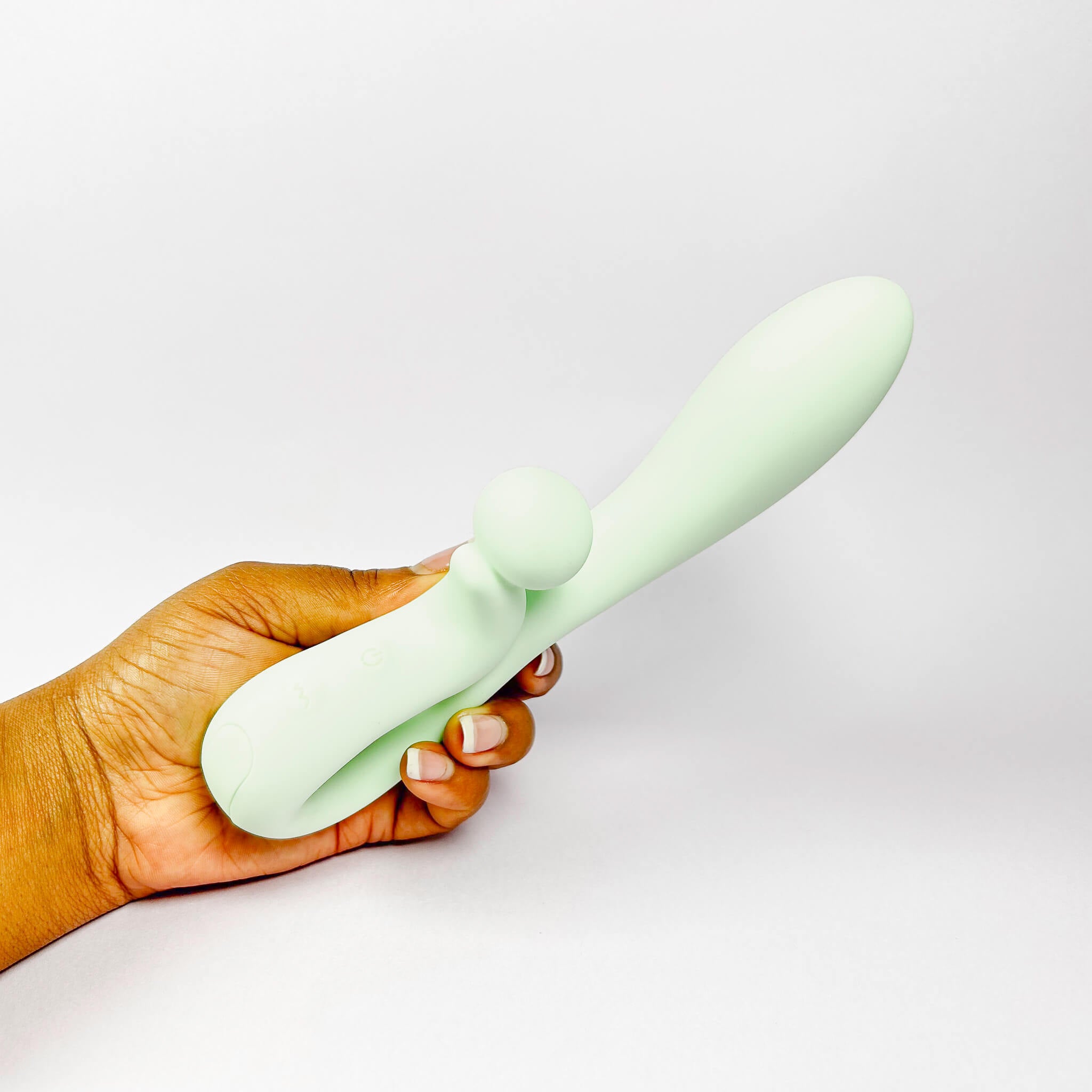 Hand holding a light green Sweet Vibe Naughty Rabbit Vibrator against a white background