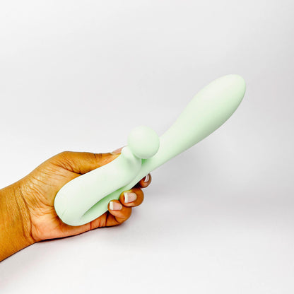 Hand holding a light green Sweet Vibe Naughty Rabbit Vibrator against a white background