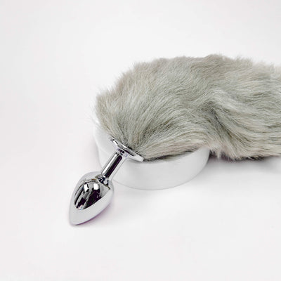 Metallic anal plug with gray fur cover on a white background