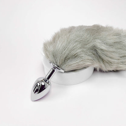 Metallic anal plug with gray fur cover on a white background