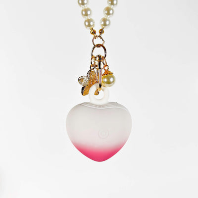 Heart-shaped discreet mini vibrator with gradient color and pearl details on a white background