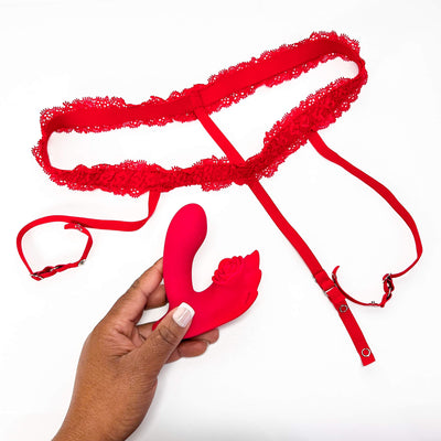 Red lace panties with a hand holding a red silicone Insertable App Controlled Panty Vibrator on a white background