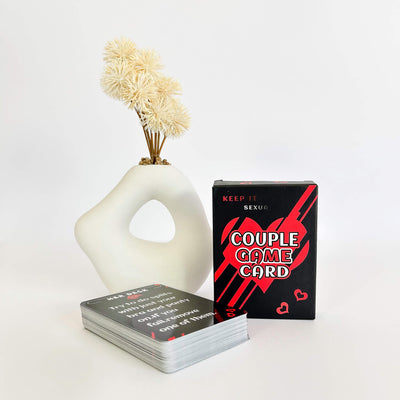 Keep it Sexual Card Game with His and Her Cards with a decorative vase on a white background