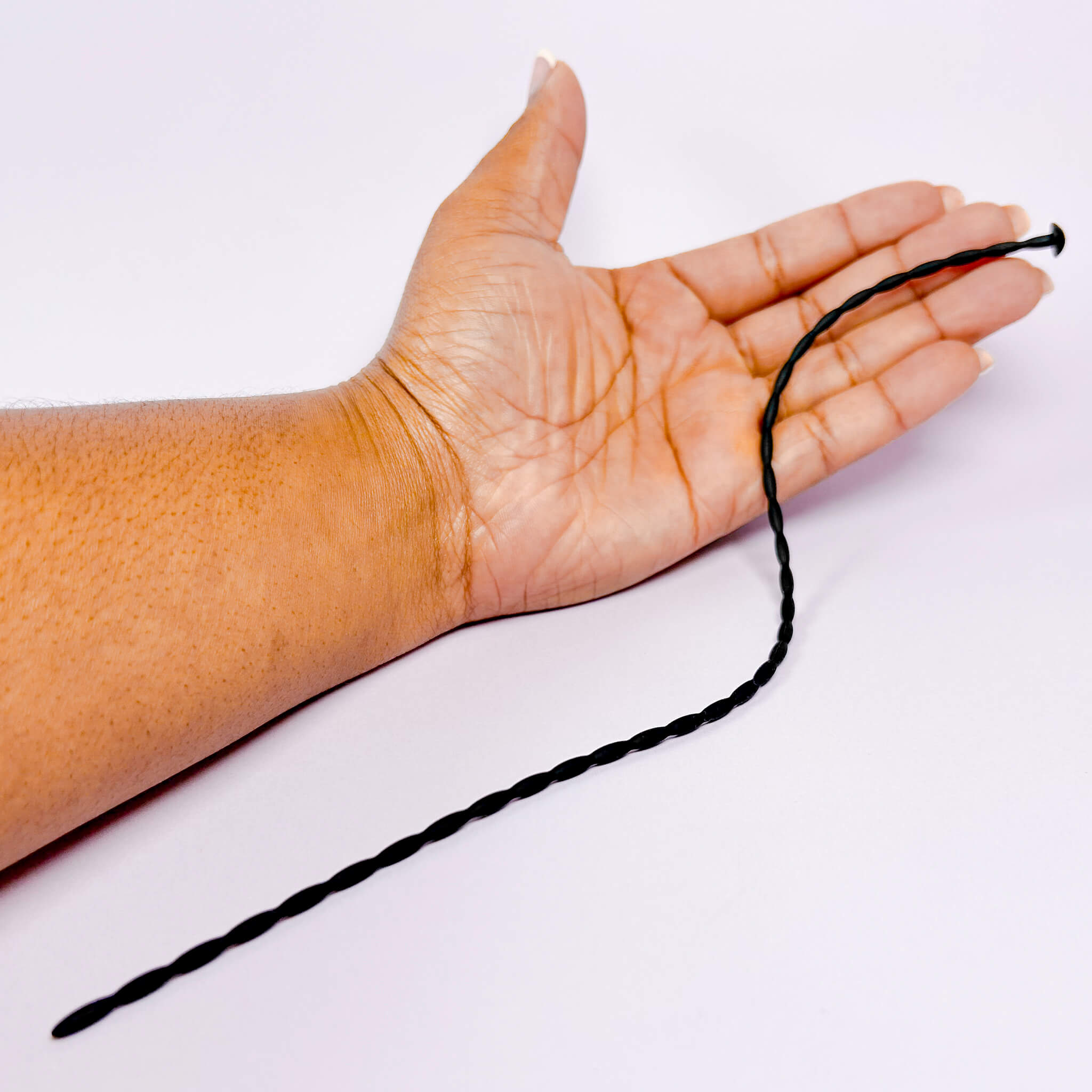 Hand holding a Long Beginners Urethral Plug against a white background
