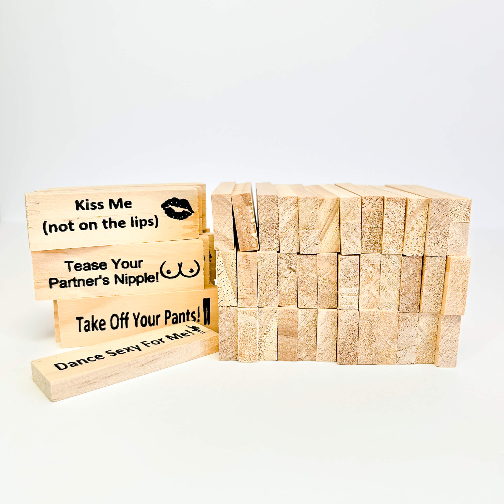 Wooden Jenga blocks with sexual innuendos on a white background